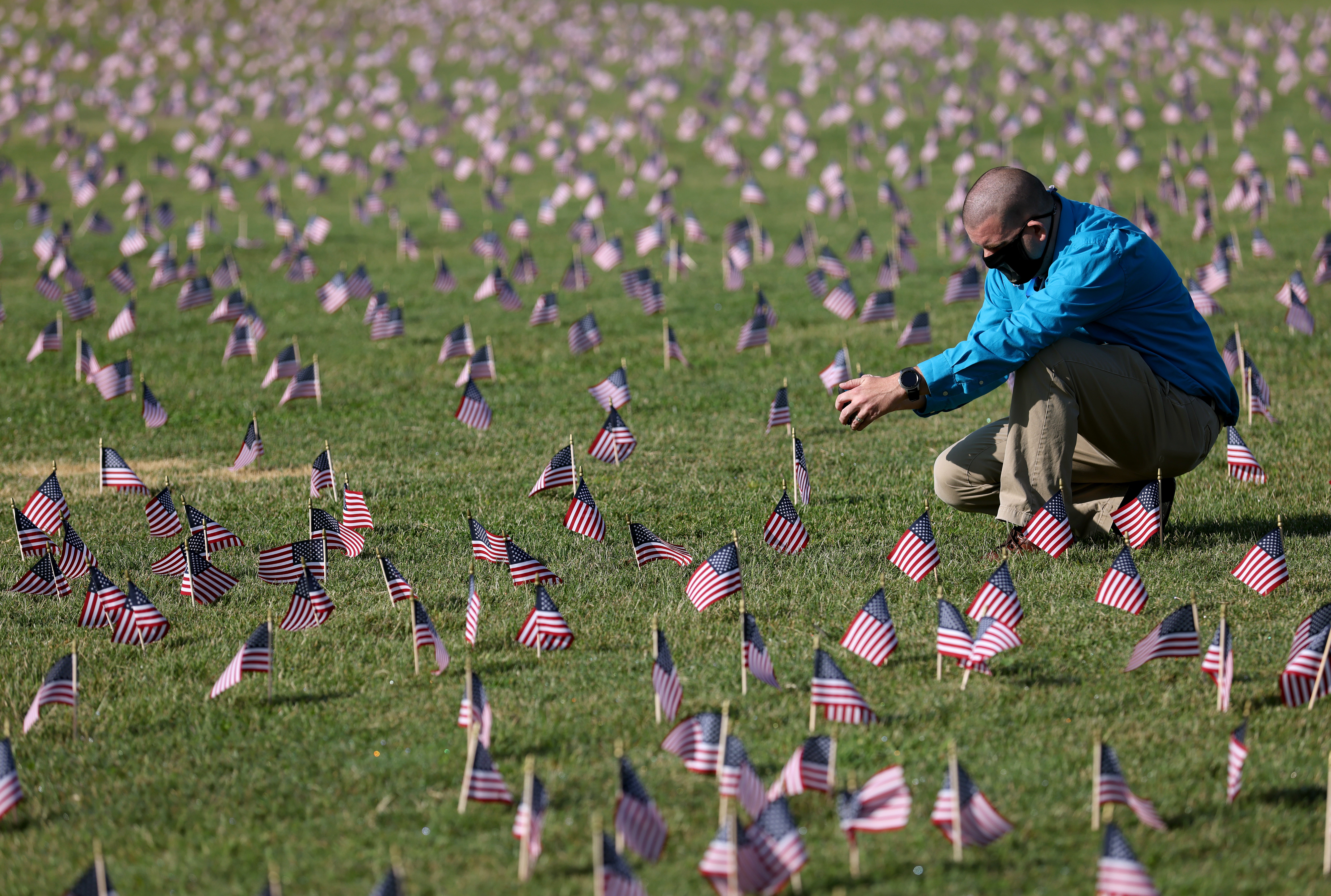 Chris Duncan, cuya madre Constance, de 75 años, murió de covid-19 el día de su cumpleaños, fotografía una instalación del Proyecto Conmemorativo de Covid-19 con 20.000 banderas estadounidenses en el National Mall de Washington, D. C.