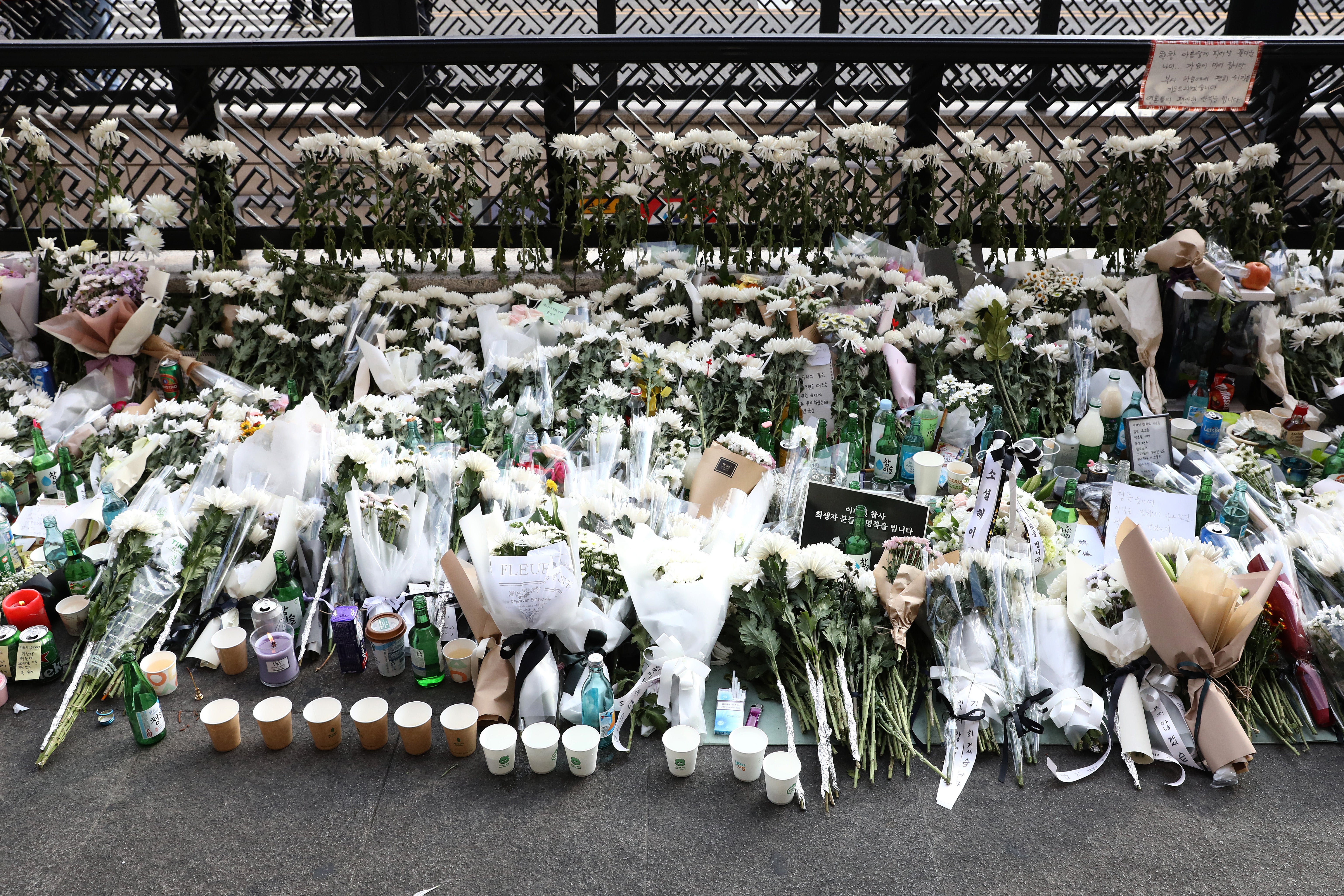 Se colocan flores en homenaje a las víctimas de la estampida de la celebración de Halloween en la calle cercana al lugar de los hechos