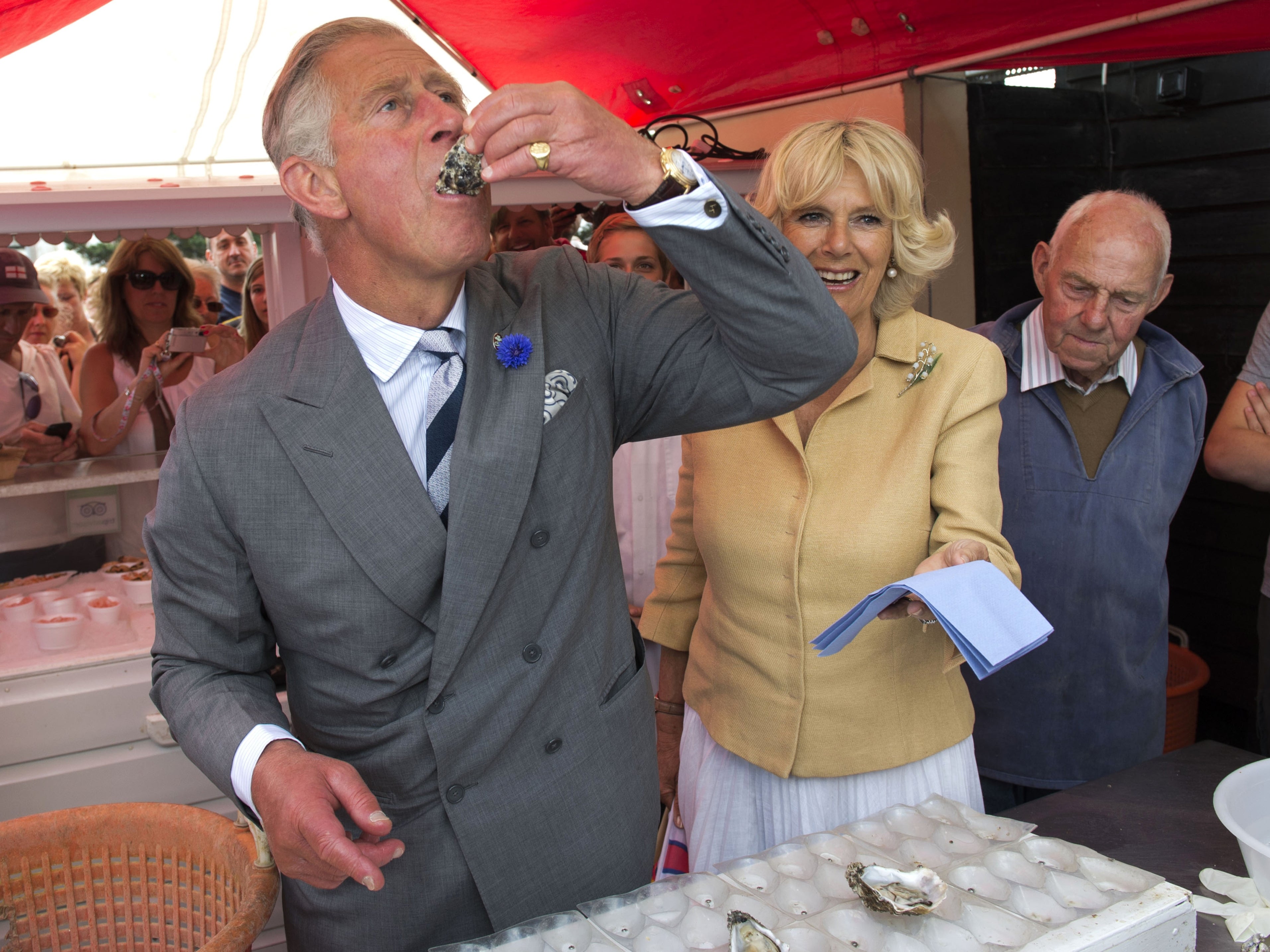 El rey Carlos degustando un ostión con la reina consorte en 2013