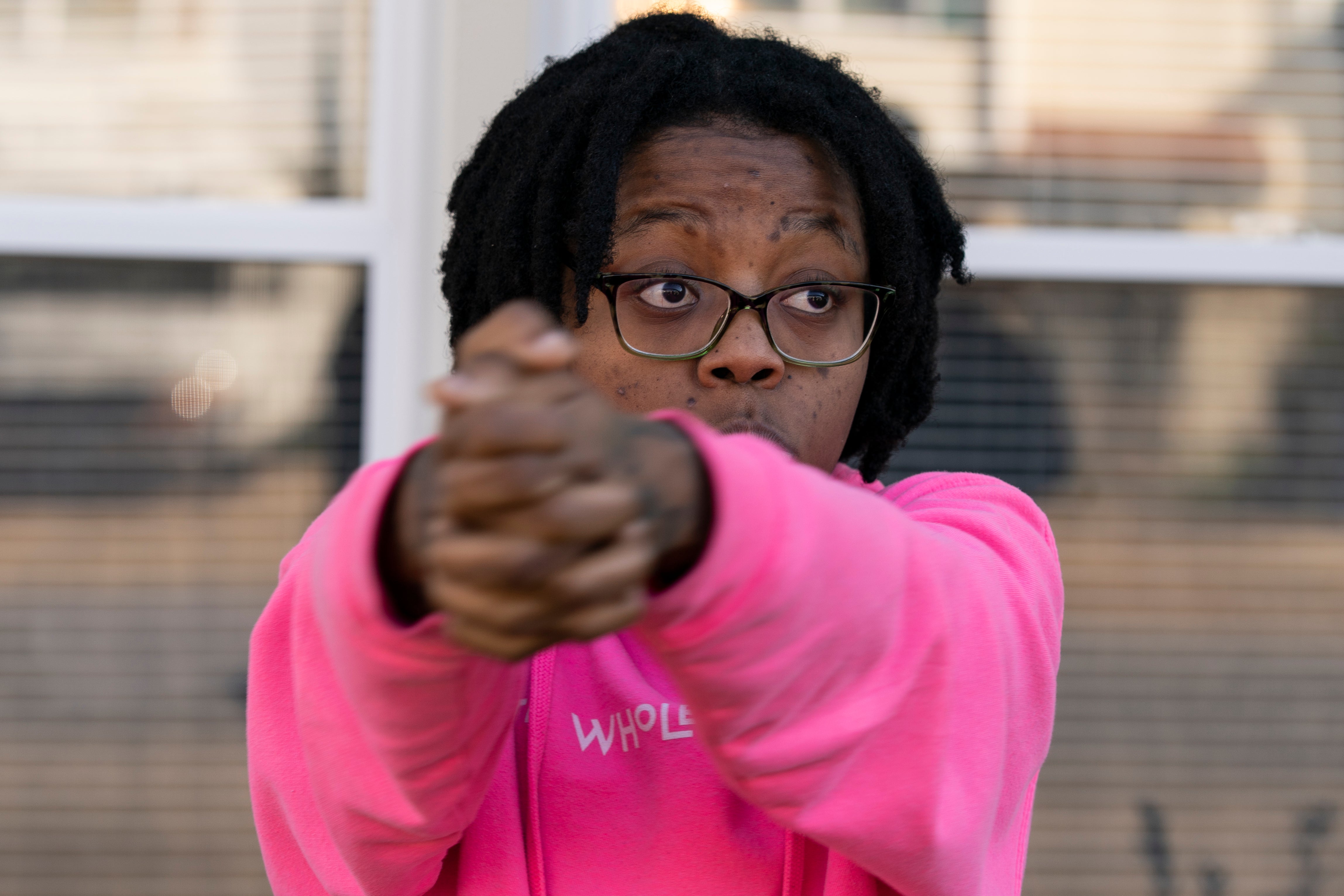 La compañera de trabajo Briana Tyler utiliza sus manos como si fueran una pistola para demostrar las acciones del autor del tiroteo en el Walmart de Chesapeake