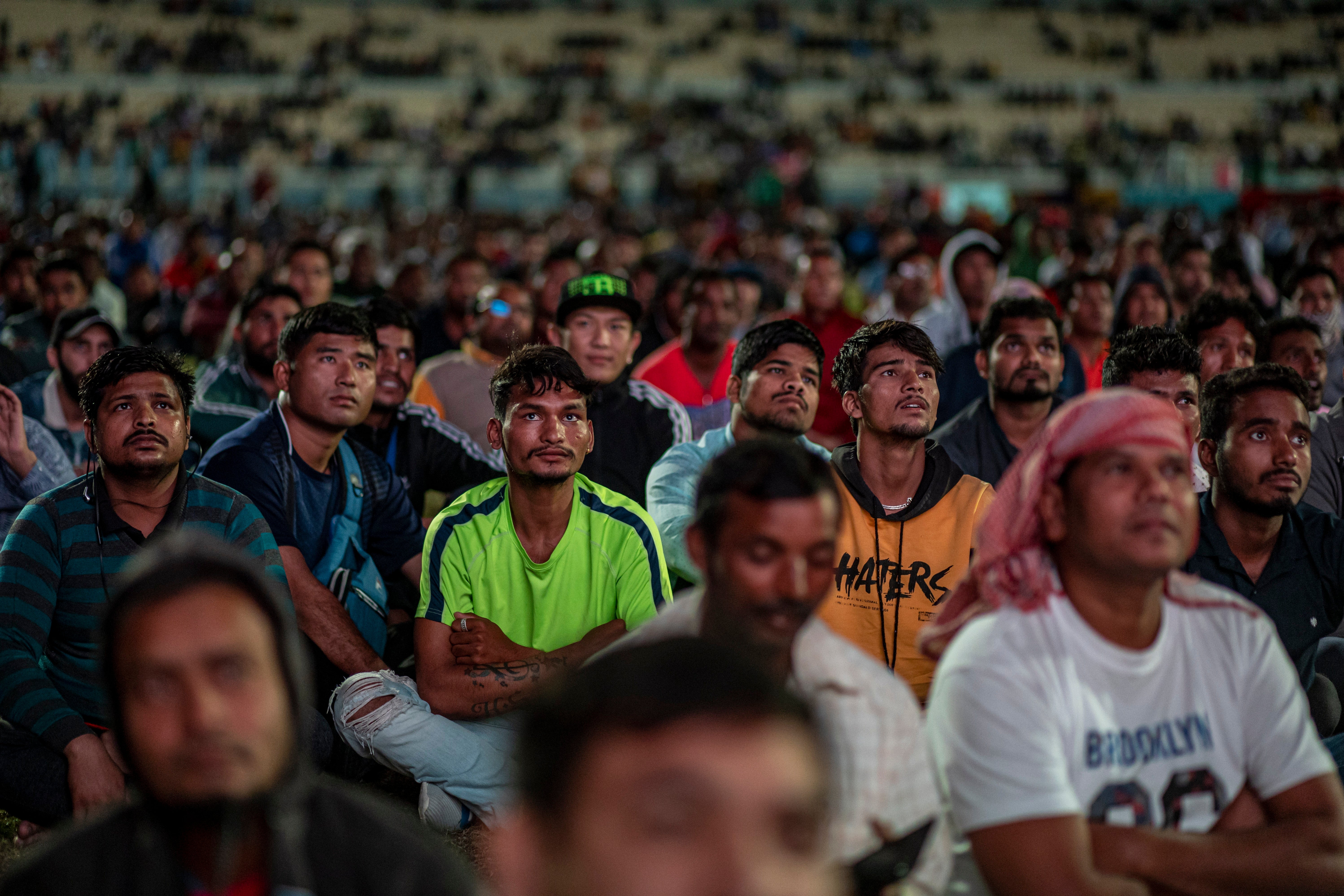 <p>Trabajadores migrantes ven la Copa del Mundo en el área de aficionados de la zona industrial de entrada libre en Doha</p>