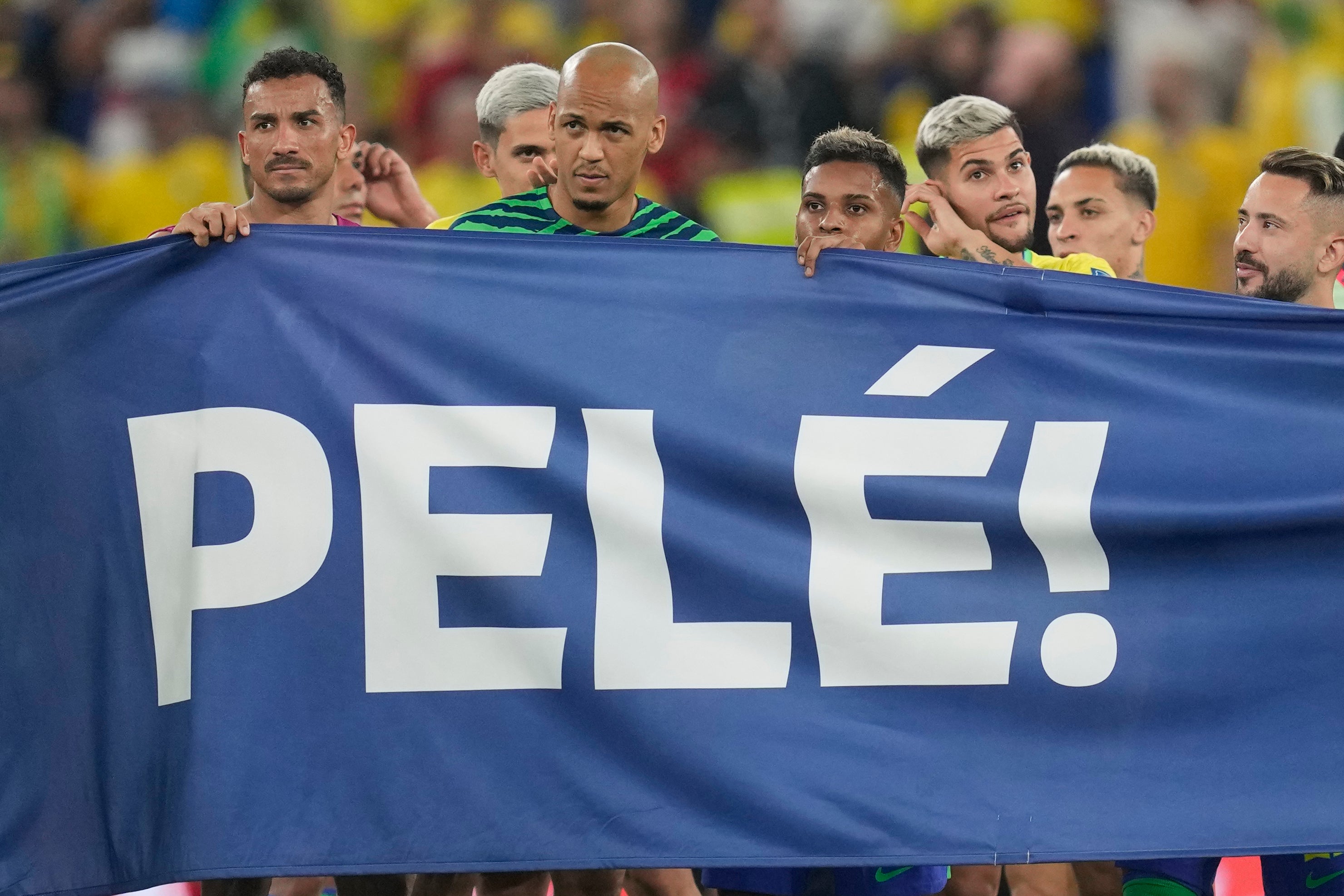 Jugadores brasileños sostienen una pancarta en honor a Pelé