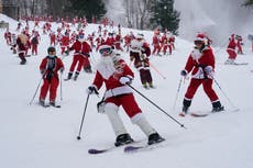 Santa Clauses esquían por una montaña en evento caritativo