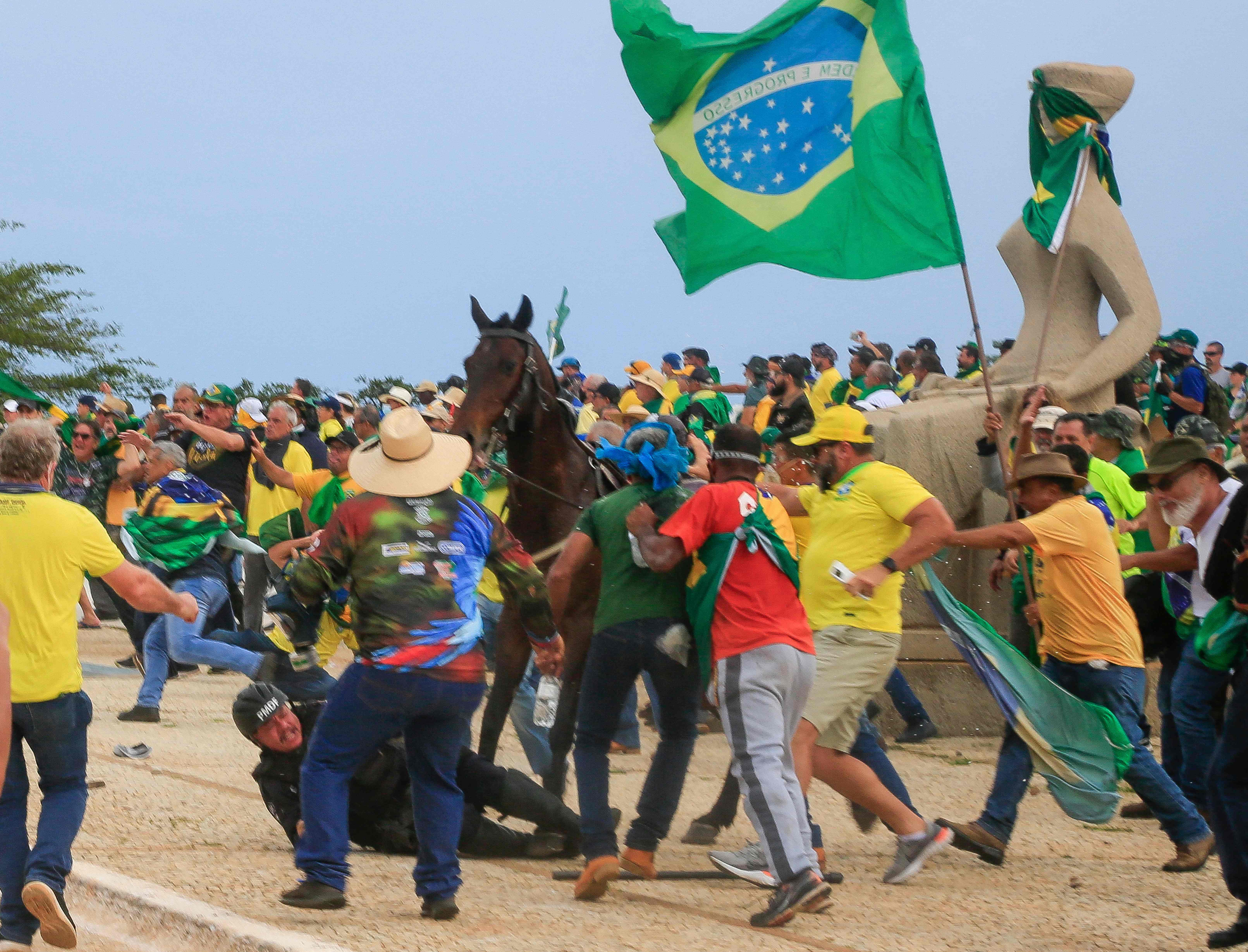 Un policía cae de su caballo durante los enfrentamientos con partidarios del expresidente brasileño Jair Bolsonaro tras una invasión del palacio presidencial de Planalto