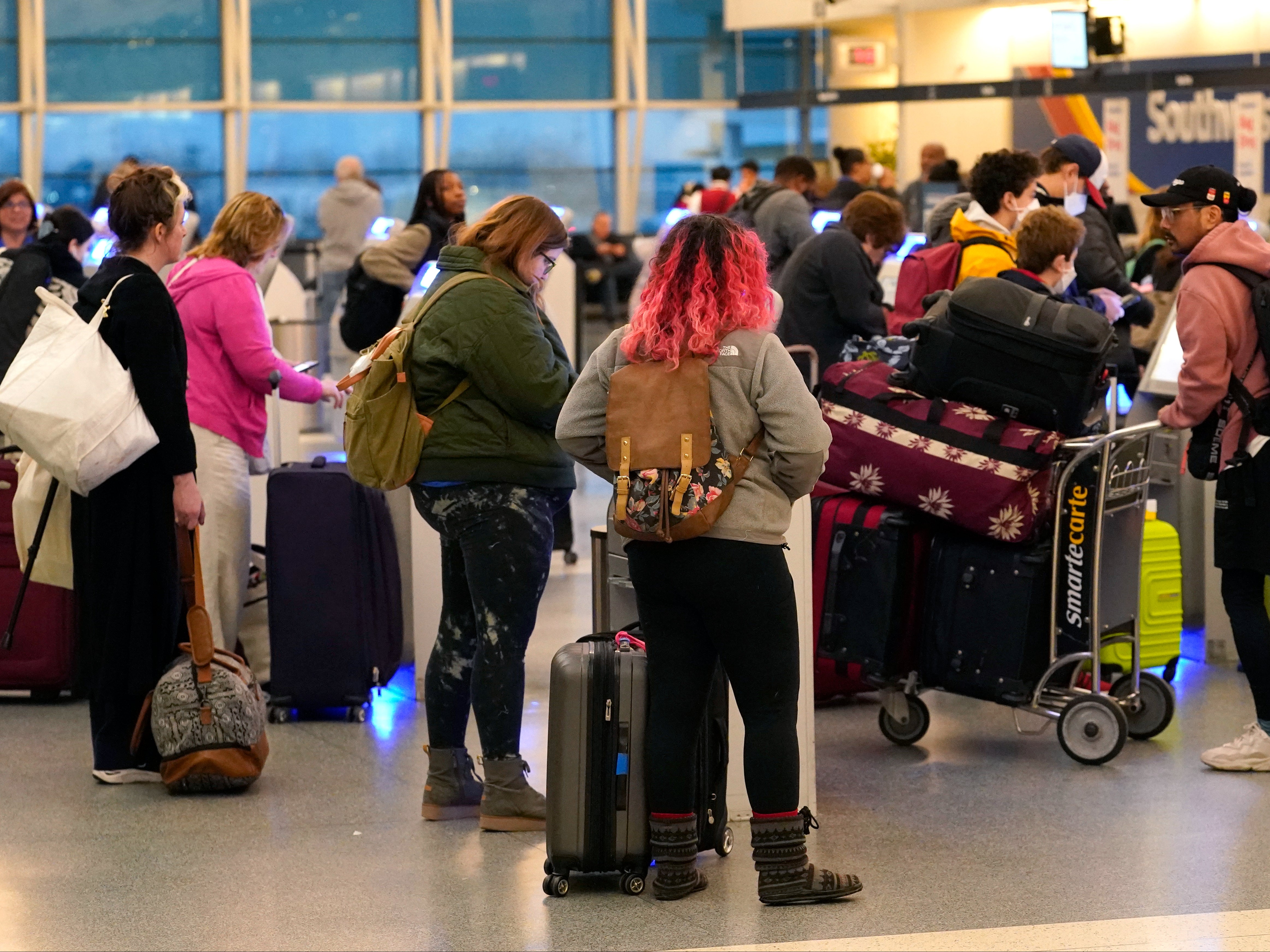 Los pasajeros hacen el check-in en los quioscos de autoservicio de Southwest Airlines en el aeropuerto Midway de Chicago mientras se producen retrasos en los vuelos debido a un fallo informático en la Administración Federal de Aviación