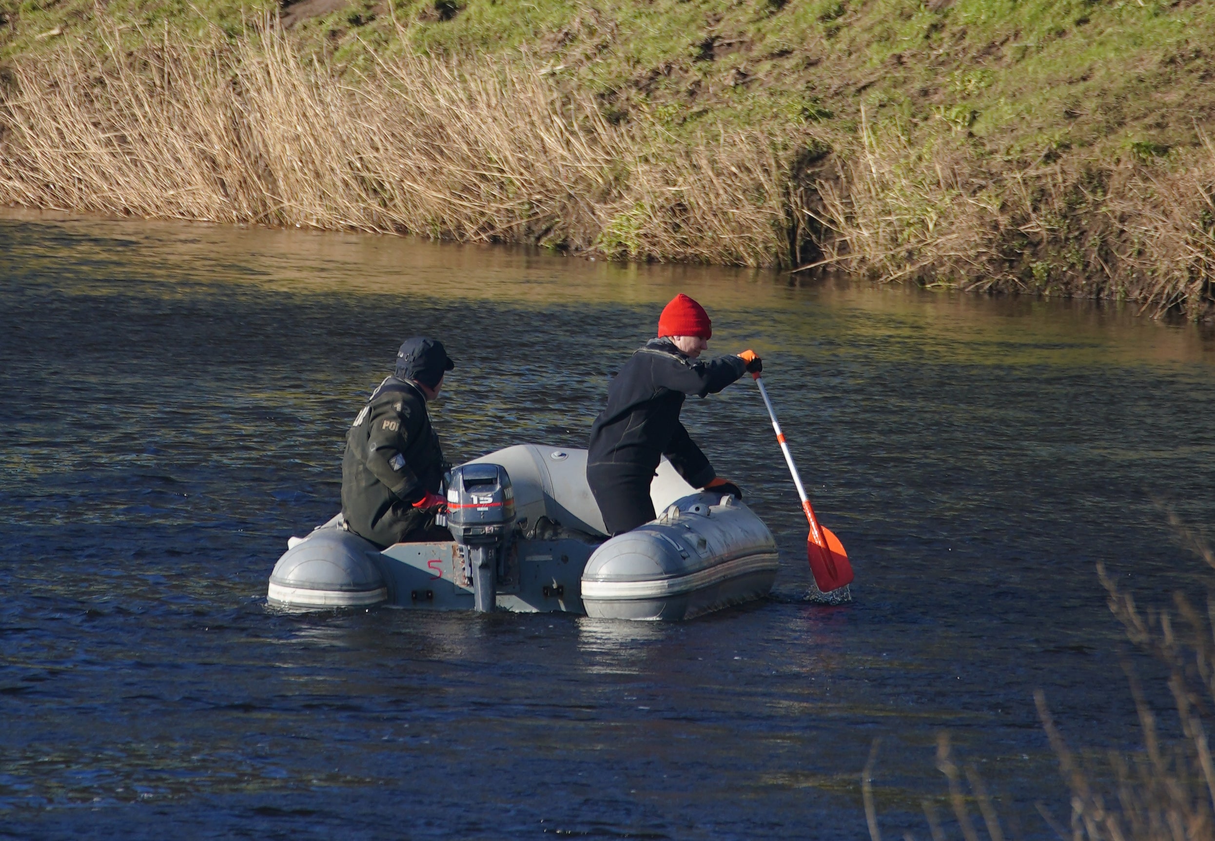 Agentes especializados en búsquedas conducen una lancha por el río Wyre
