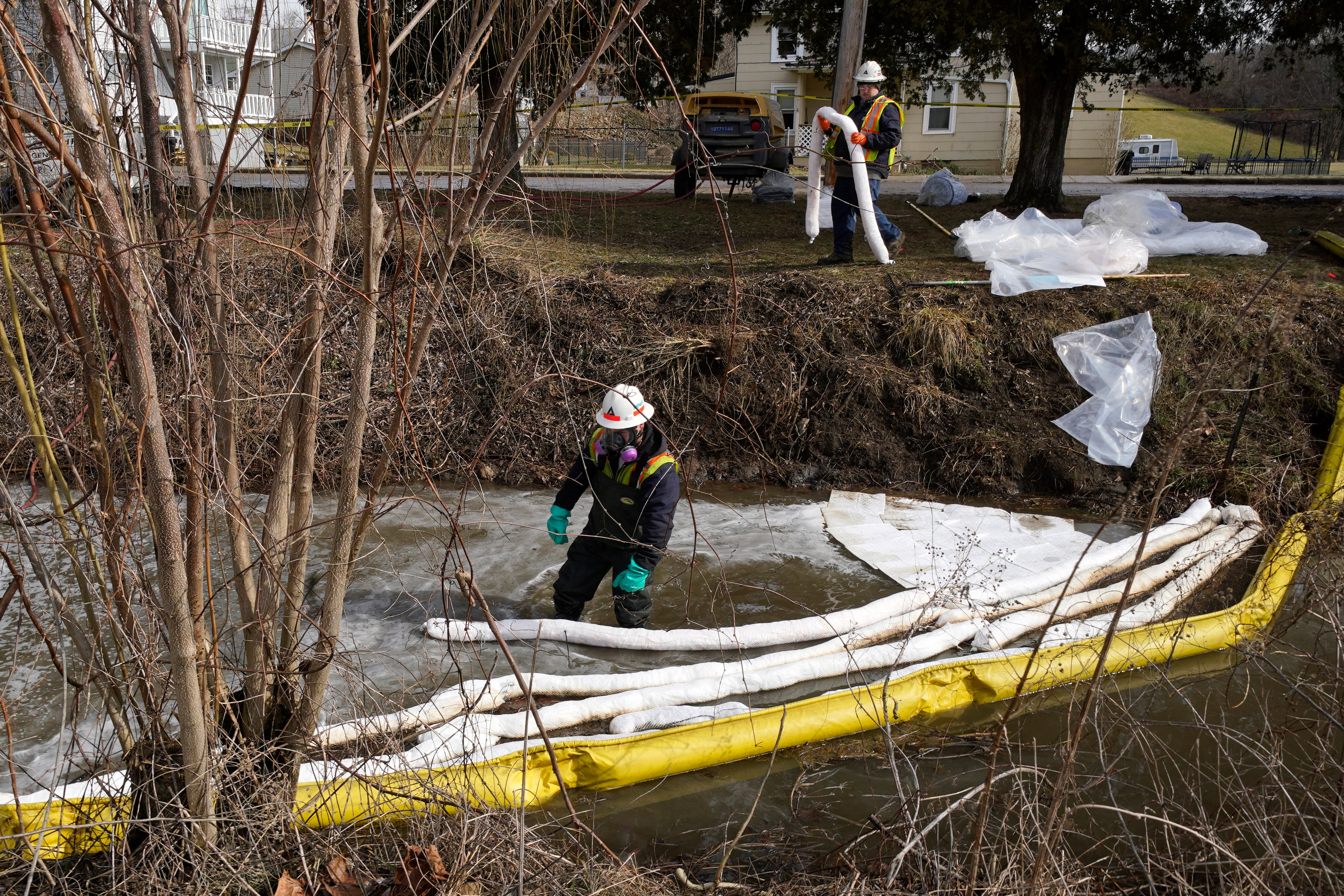 Equipos de contaminación colocan barreras en un arroyo en East Palestine, Ohio, el jueves, mientras continúa la limpieza tras el descarrilamiento de un tren de mercancías de Norfolk Southern