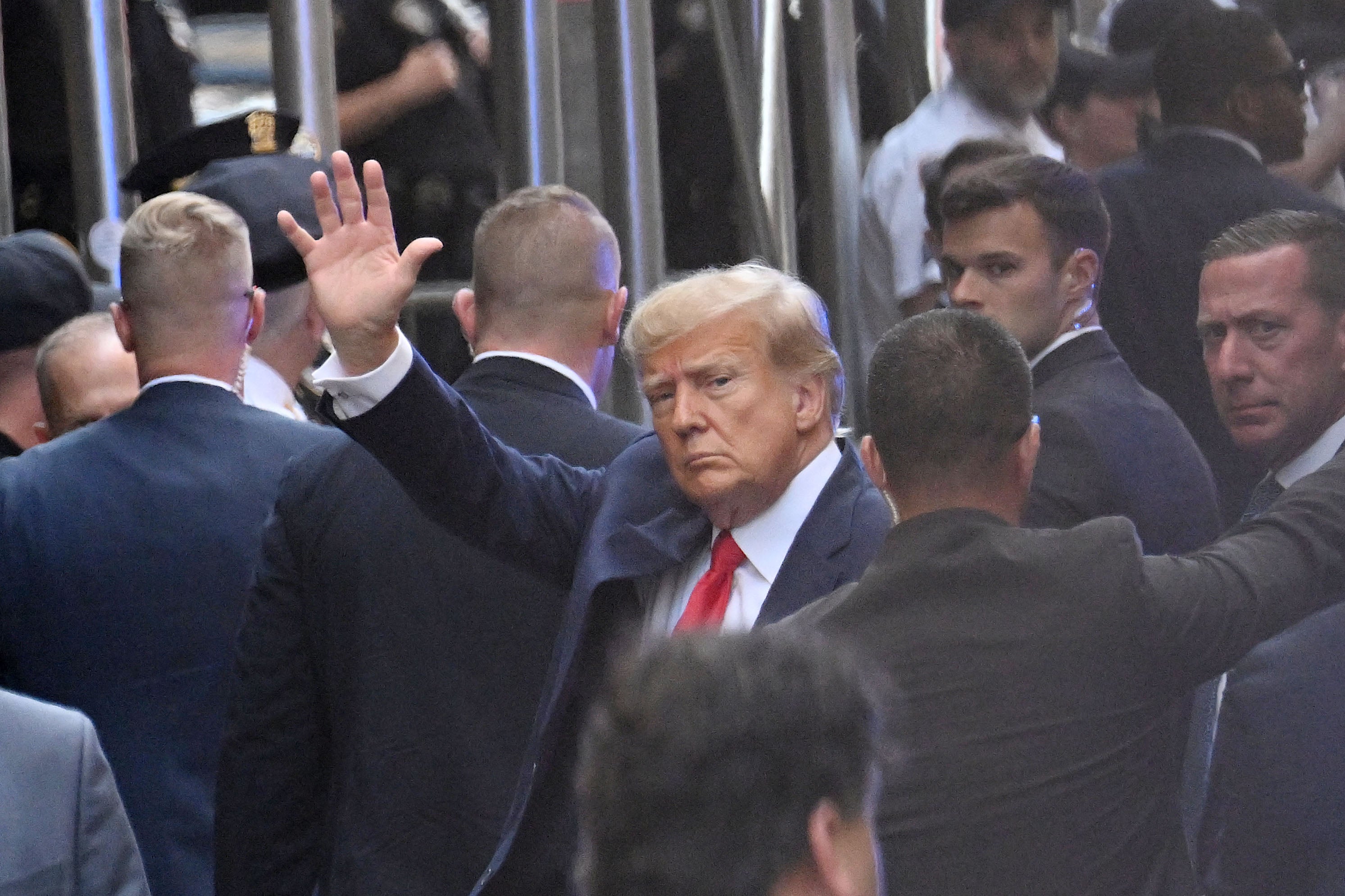 Donald Trump saluda a sus simpatizantes al llegar a la corte de Manhattan en la tarde del jueves
