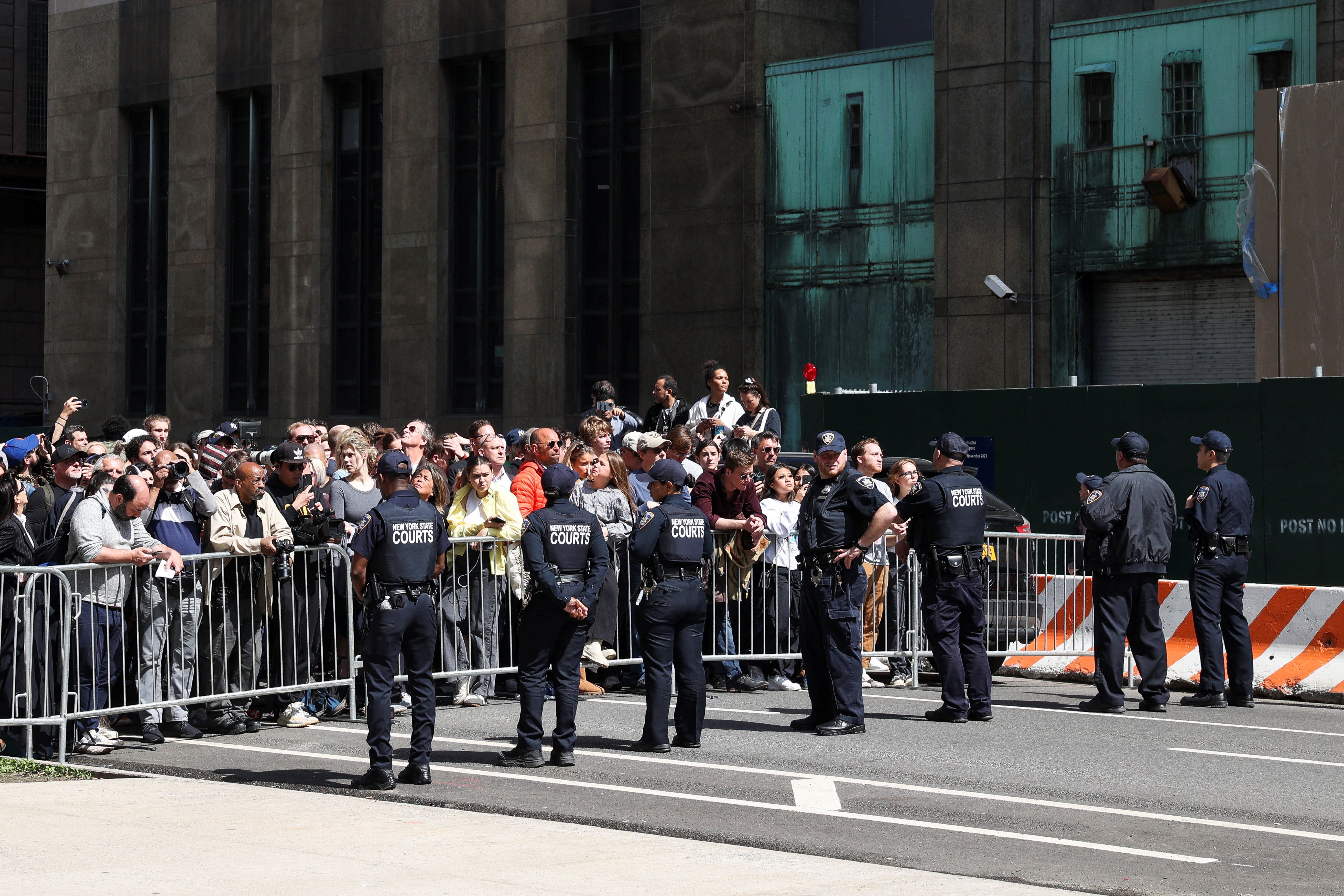 Los agentes de las fuerzas del orden vigilan a las multitudes afuera de la corte penal de Manhattan el martes durante la lectura de cargos de Donald Trump