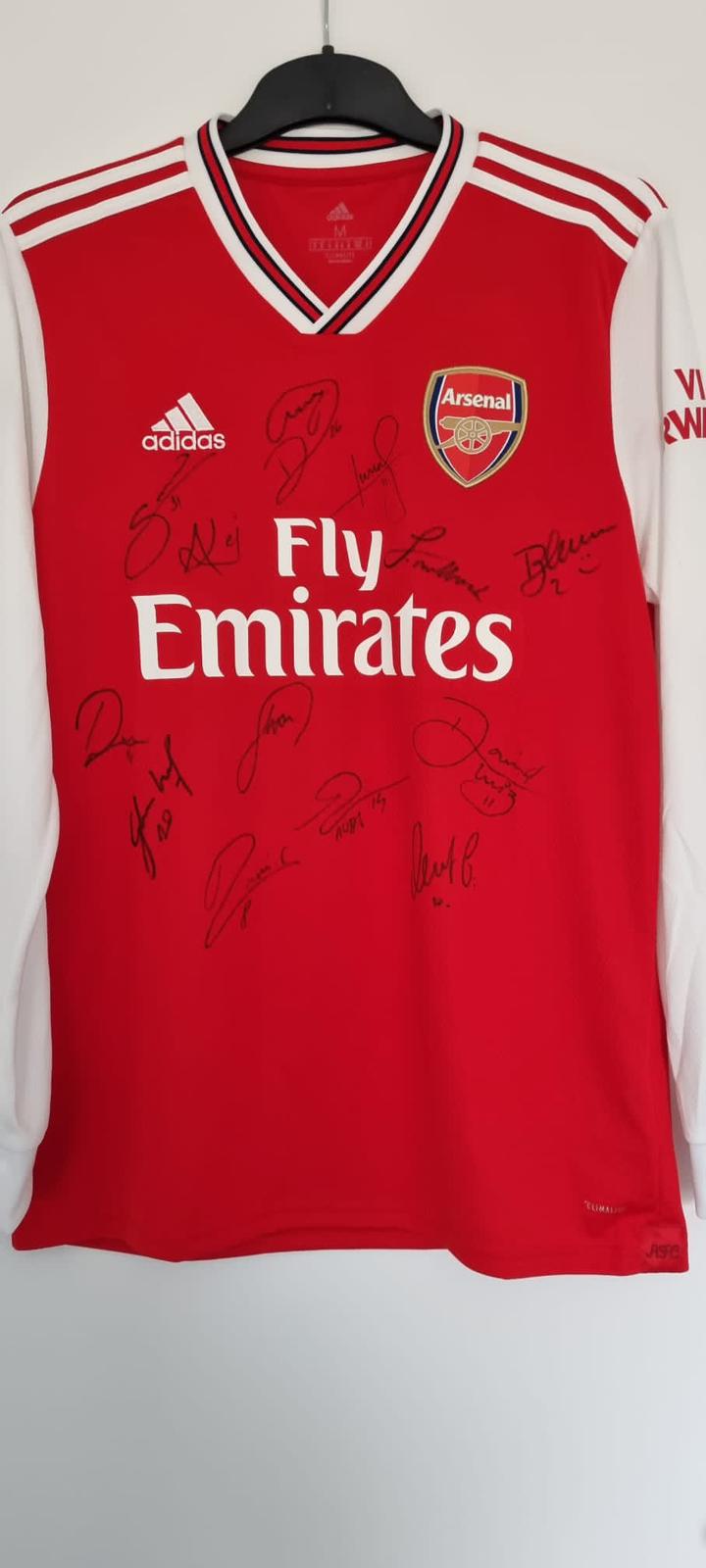 Una camiseta del Arsenal firmada por el primer equipo masculino que le regalaron a Cain deseándole una buena recuperación