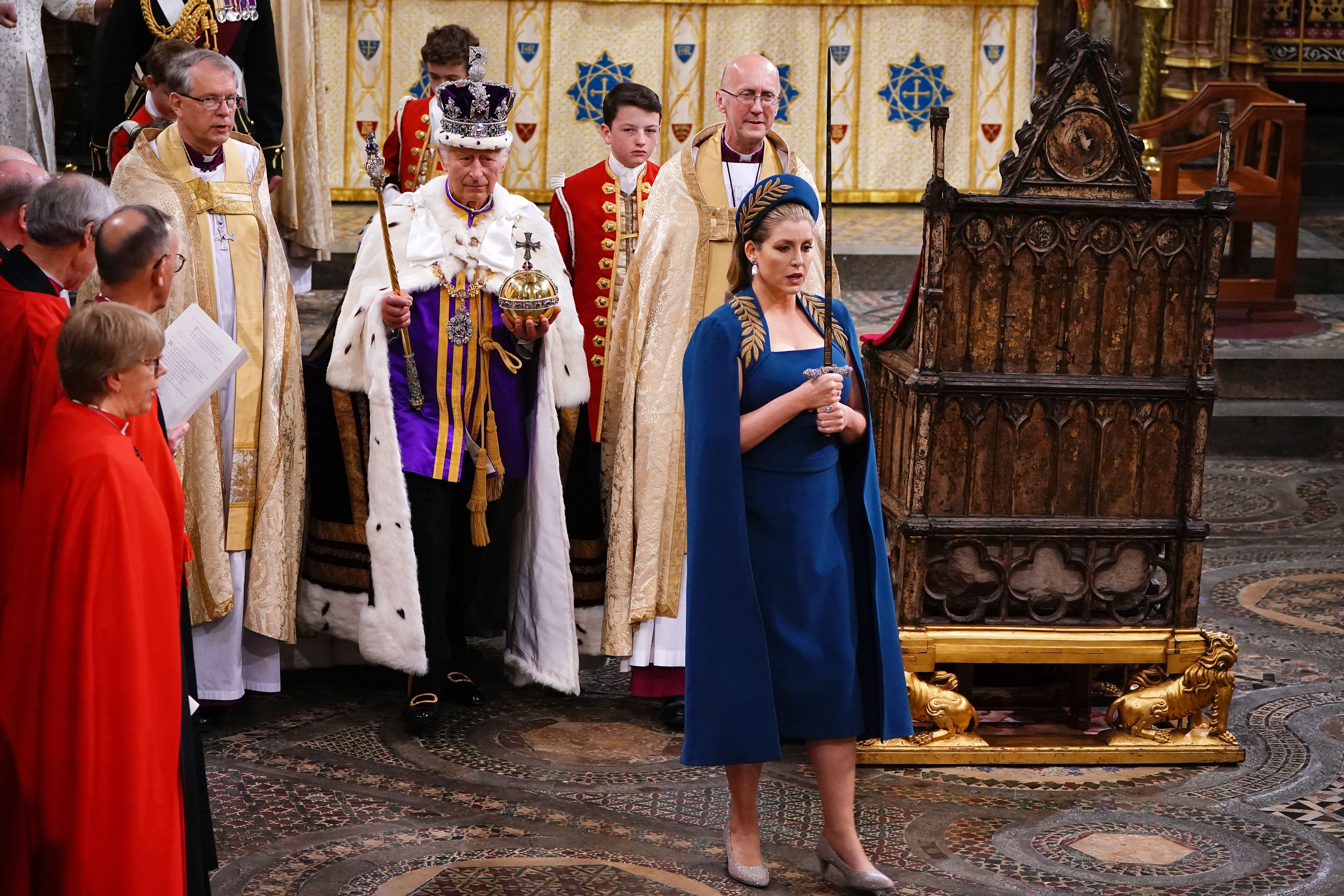 Penny Mordaunt sostiene la Espada del Estado al caminar delante de Carlos III en la coronación