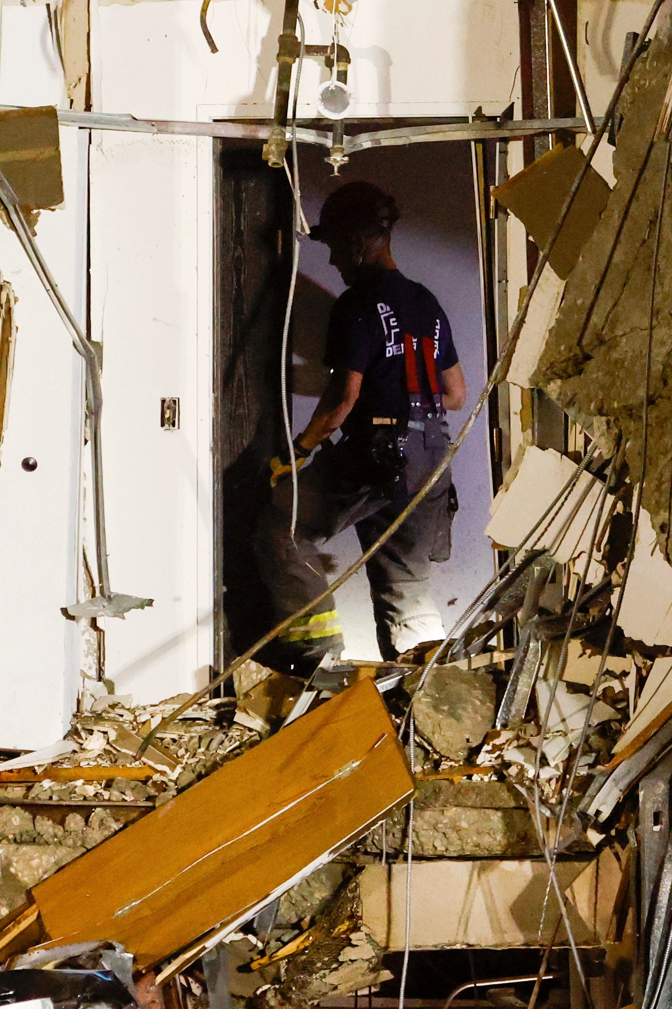 Un bombero atraviesa los escombros del edificio derrumbado