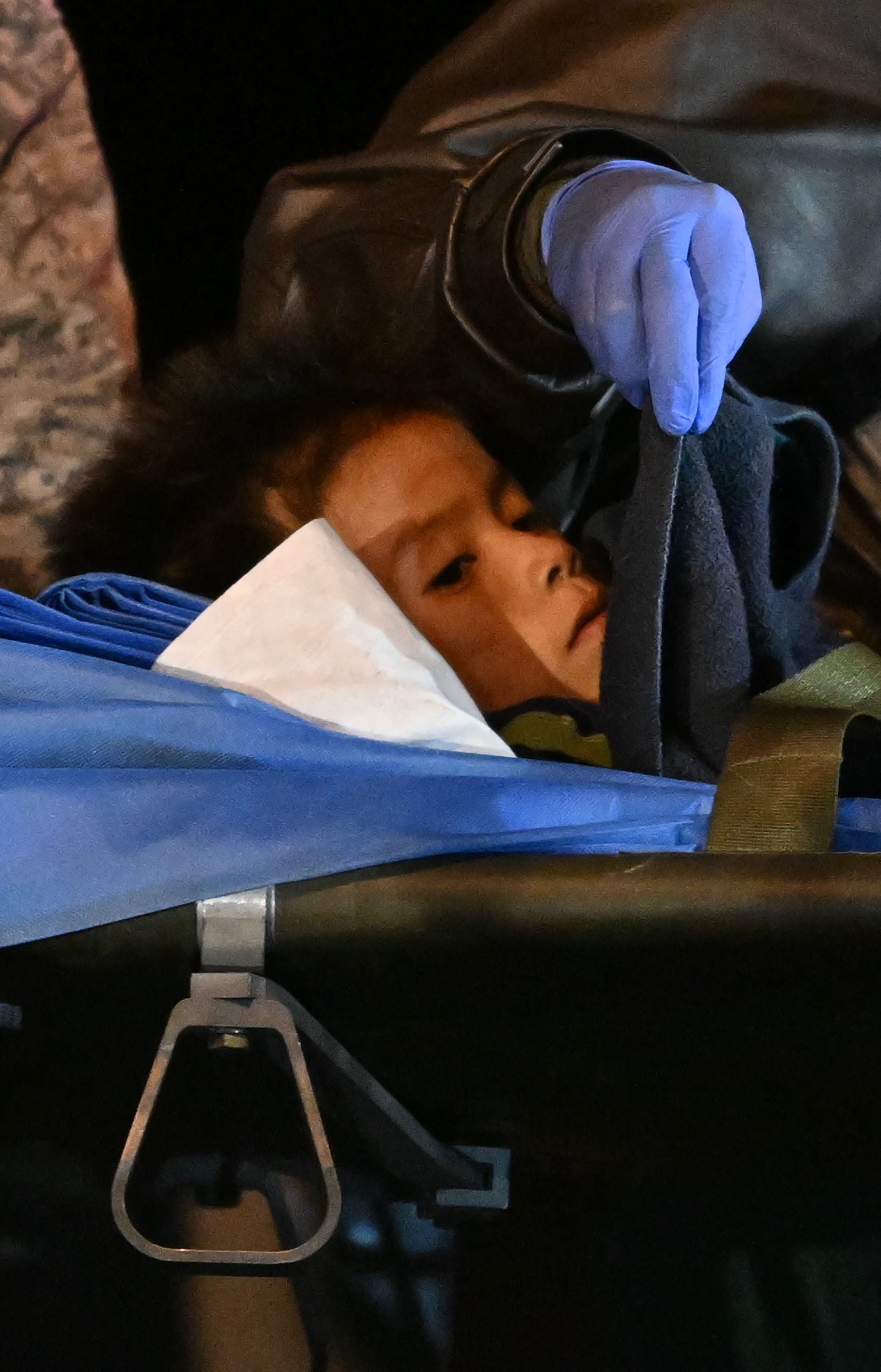 Uno de los cuatro niños sale en camilla de un avión tras aterrizar en la base militar en Bogotá el sábado