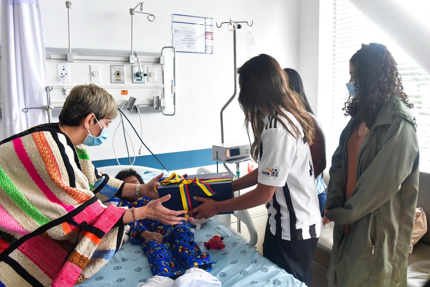 La primera dama colombiana Verónica Alcocer (izquierda) ofrece un regalo a uno de los niños