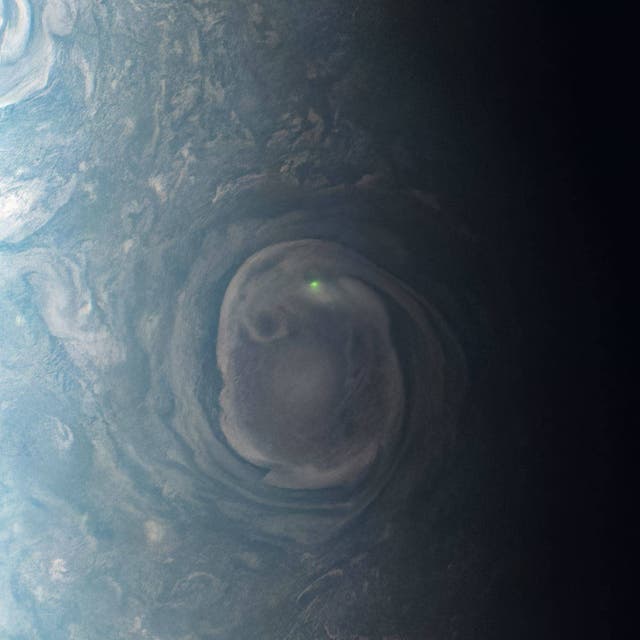<p>NASA’s Juno mission captured the green glow from a bolt of lightning above the planet</p>