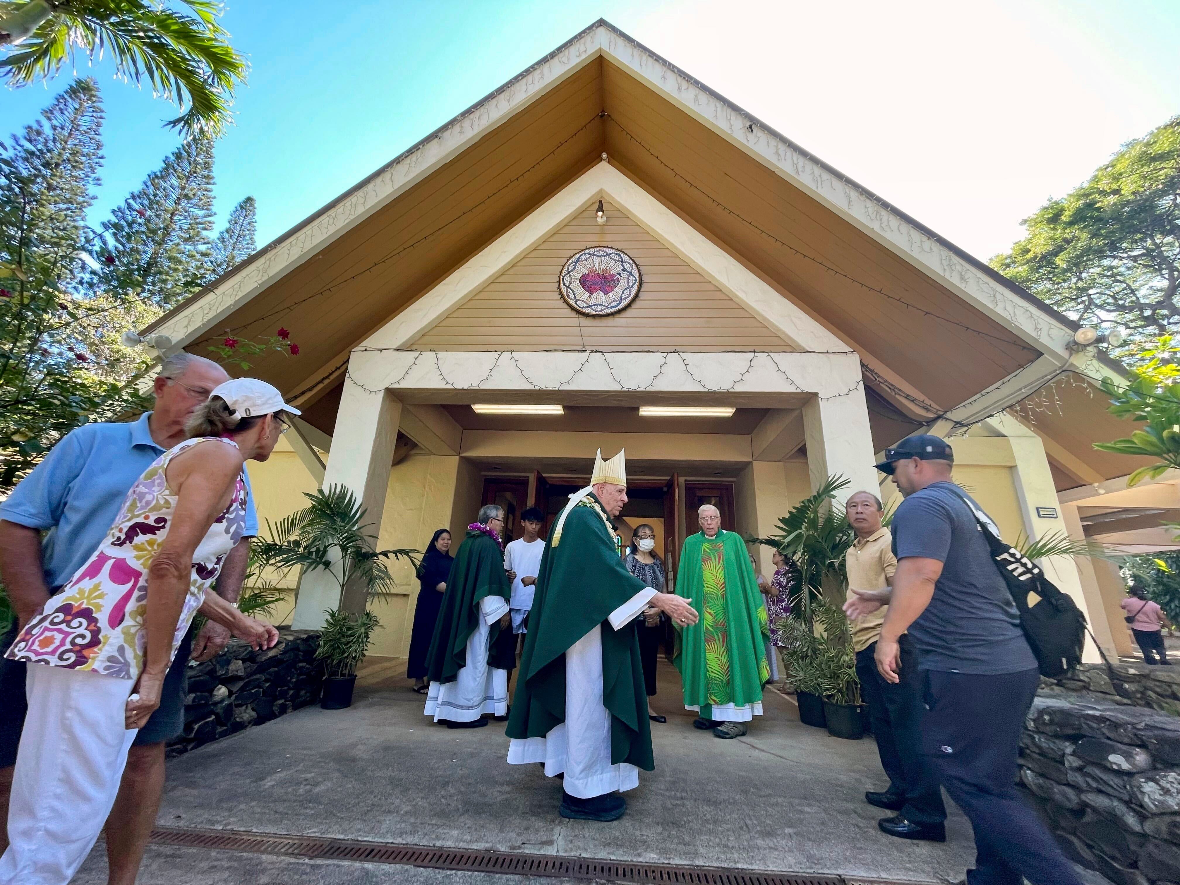 El reverendo Clarence “Larry” Silva, obispo de Honolulu, saluda a los feligreses tras la misa celebrada el domingo en la iglesia de la Misión de los Sagrados Corazones, que se salvó de los incendios