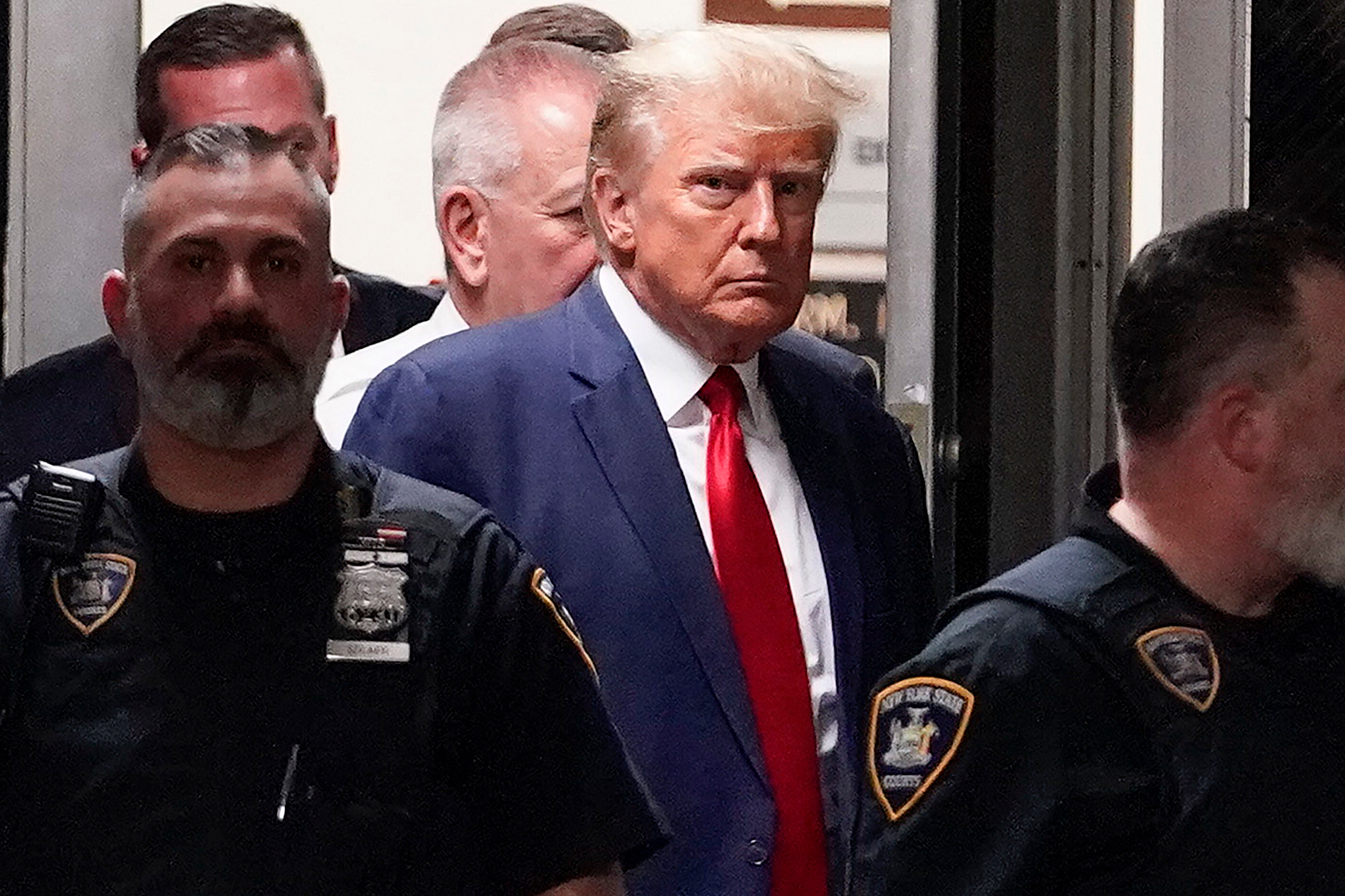 El expresidente Donald Trump es escoltado a una sala del tribunal de Nueva York el 4 de abril de 2023 para responder a la acusación estatal que le acusa de falsificar registros comerciales para tapar un soborno que pagó a la actriz porno Stormy Daniels