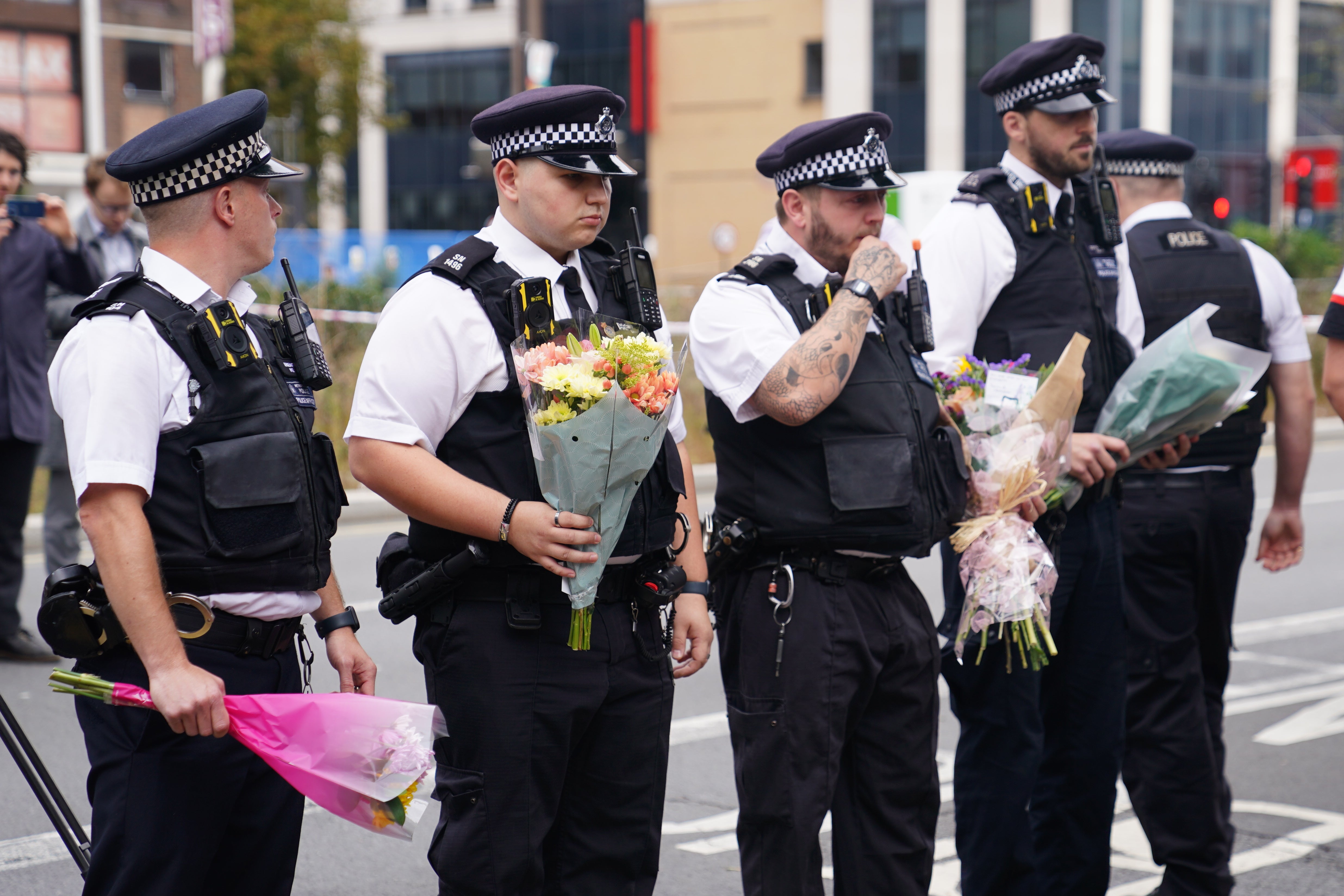Policías colocan flores en la escena en Croydon