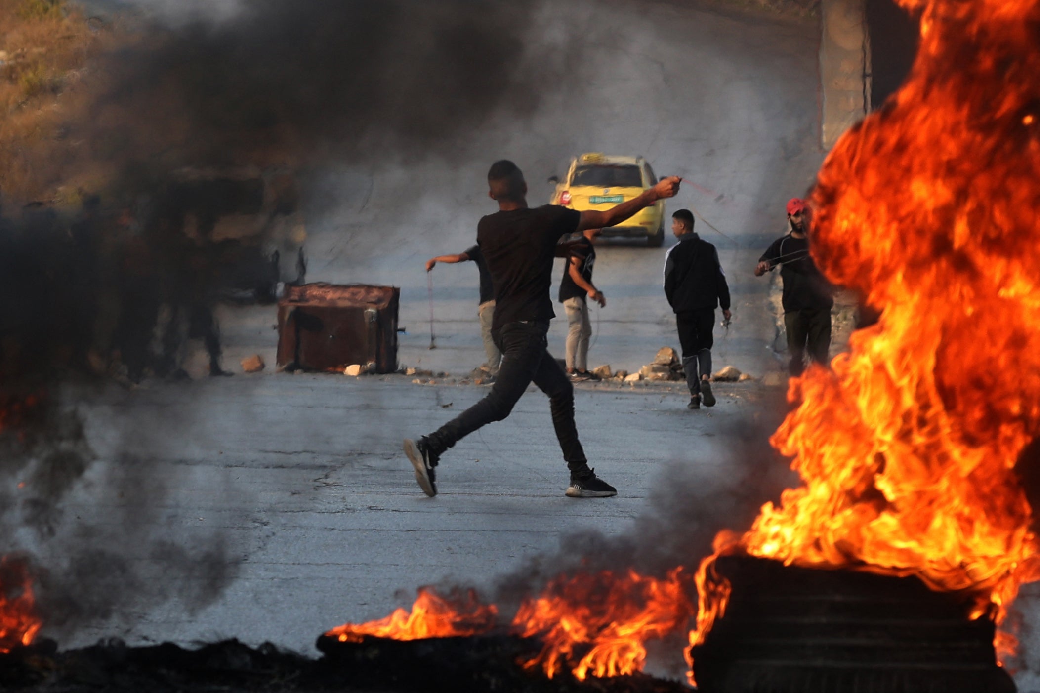 Manifestante palestino arroja piedras a los soldados israelíes en confrontaciones ocurridas el domingo en la ciudad de Ramala, en la Cisjordania ocupada.