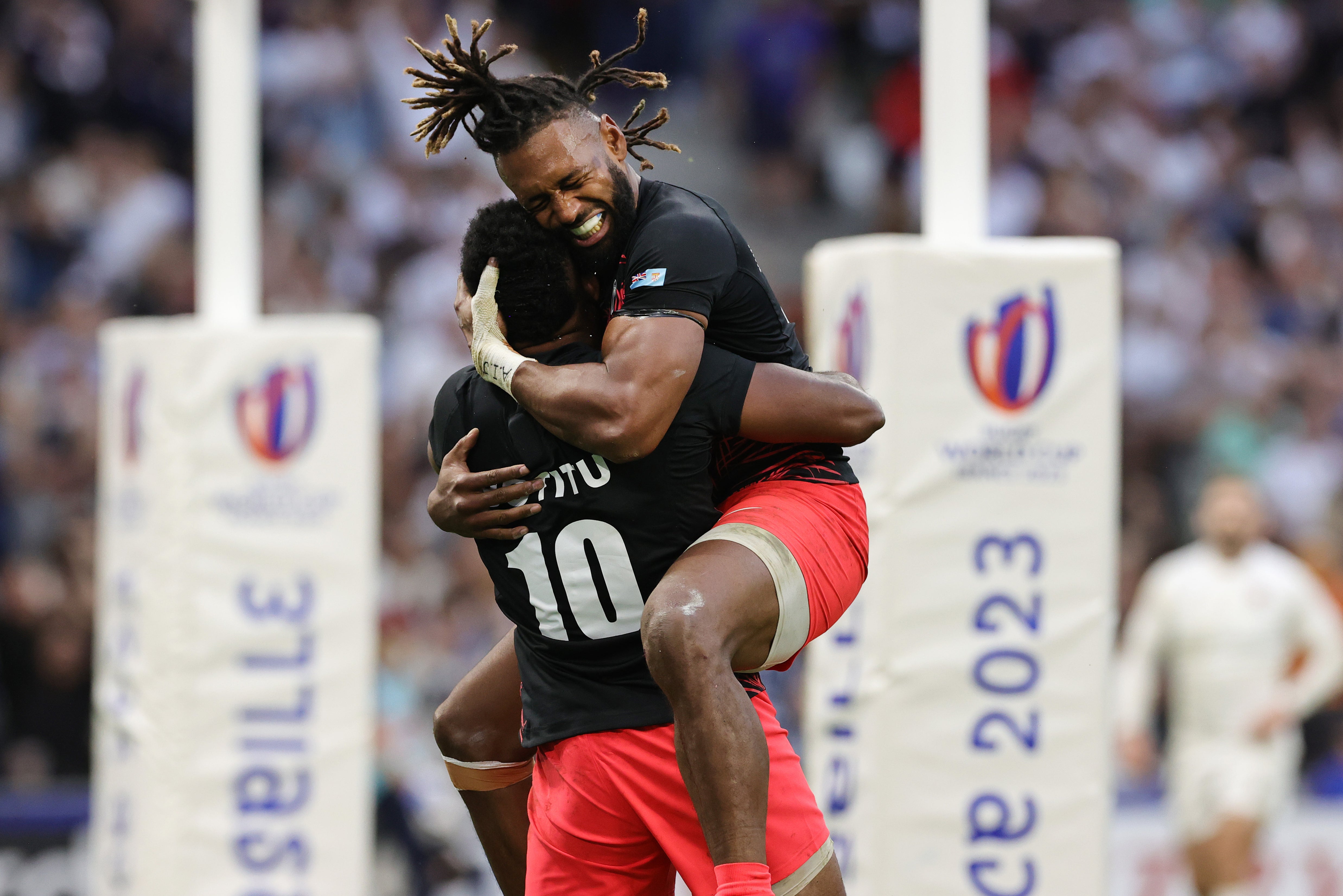 El capitán Waisea Nayacalevu abraza a Vilimoni Botitu después de que el medio apertura anotara un try contra Inglaterra.
