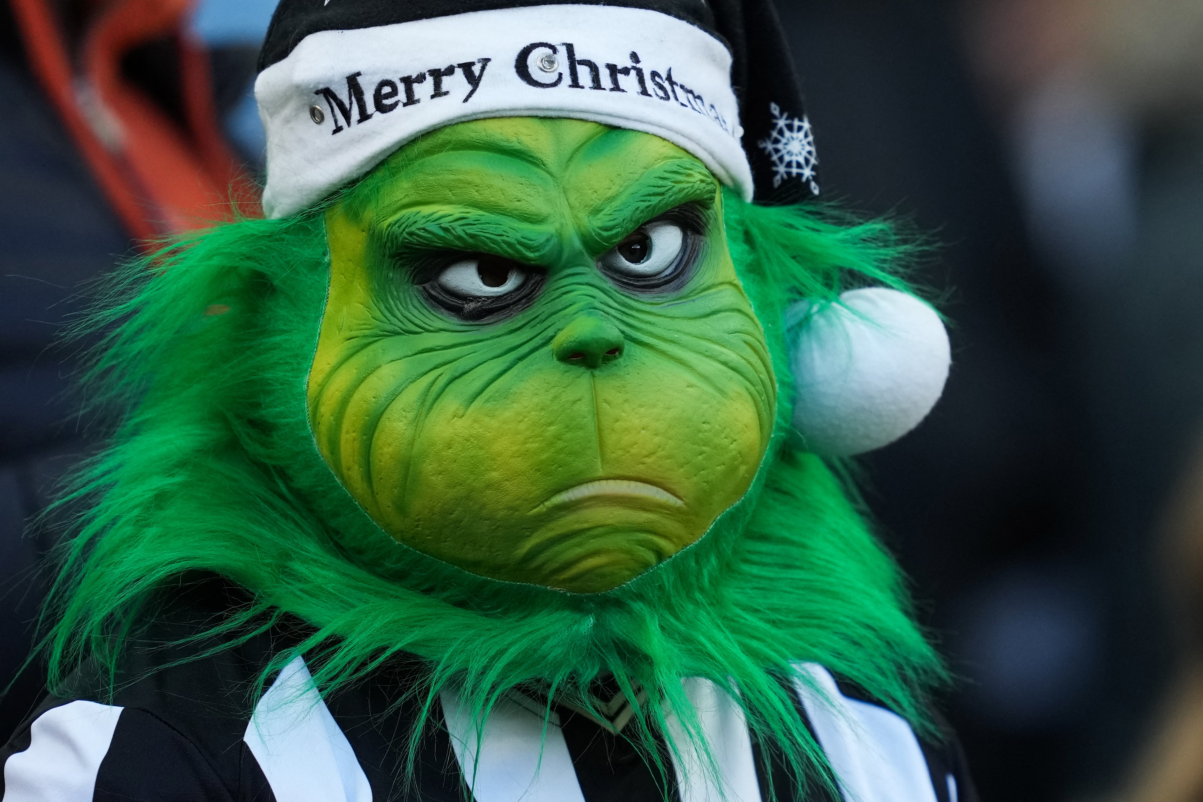 Un aficionado del equipo de fútbol Newcastle United lleva una máscara del Grinch