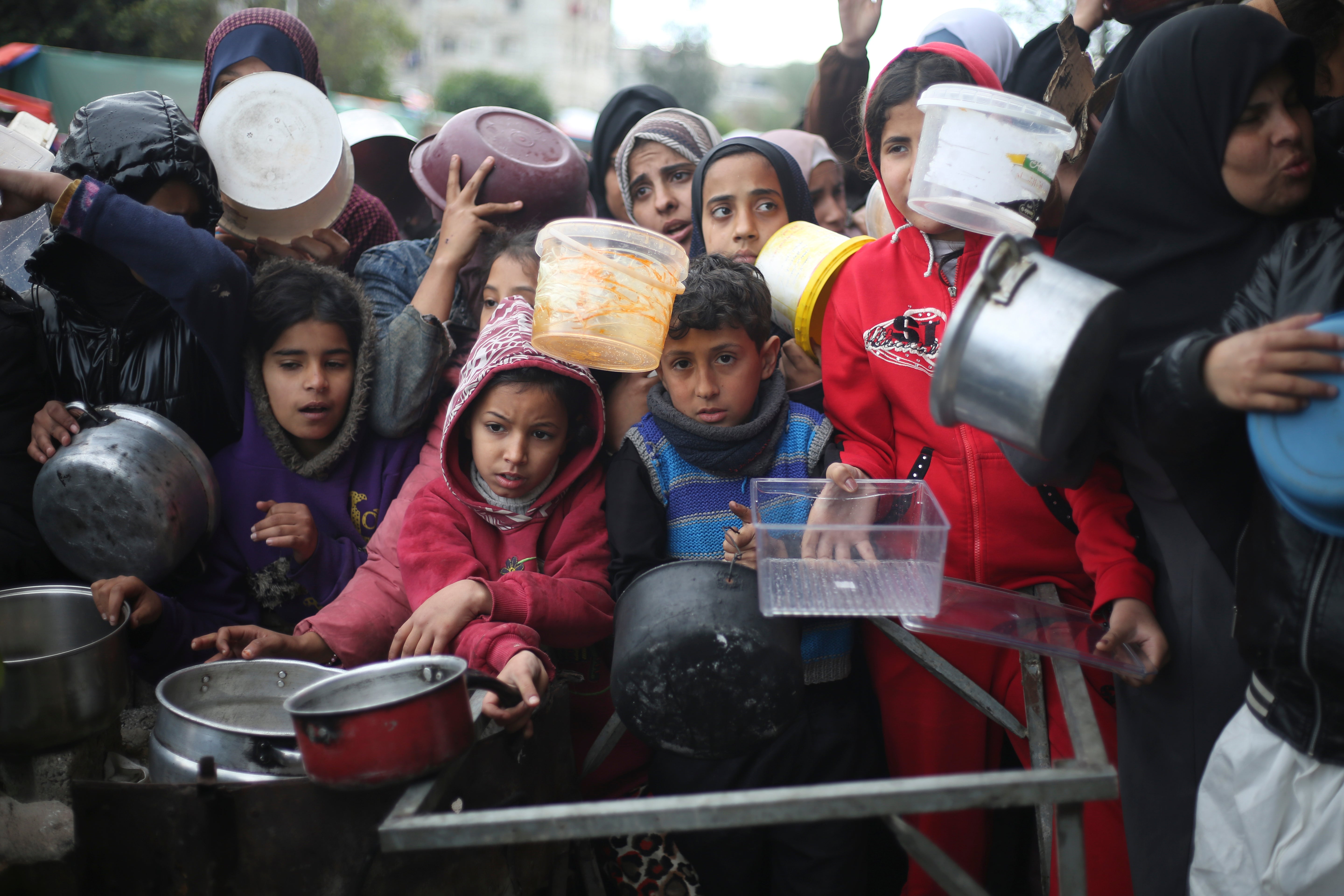 Palestinos aguardan para recibir alimentos durante la ofensiva aérea y terrestre israelí en la Franja de Gaza, el viernes 2 de febrero de 2024.
