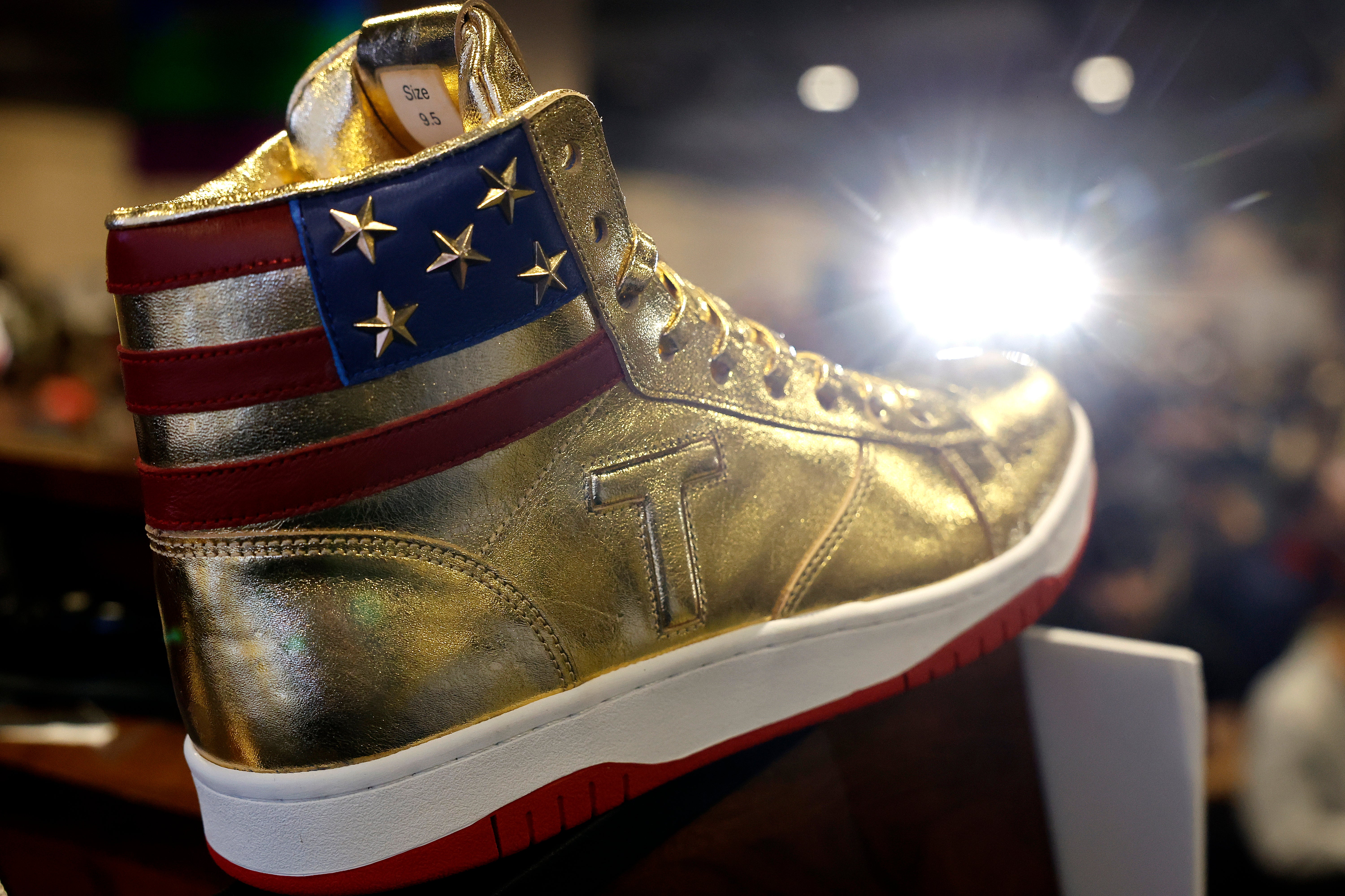 Las zapatillas doradas de caña alta llevan una gran “T” al costado y la bandera de EE. UU. cosida alrededor del cuello