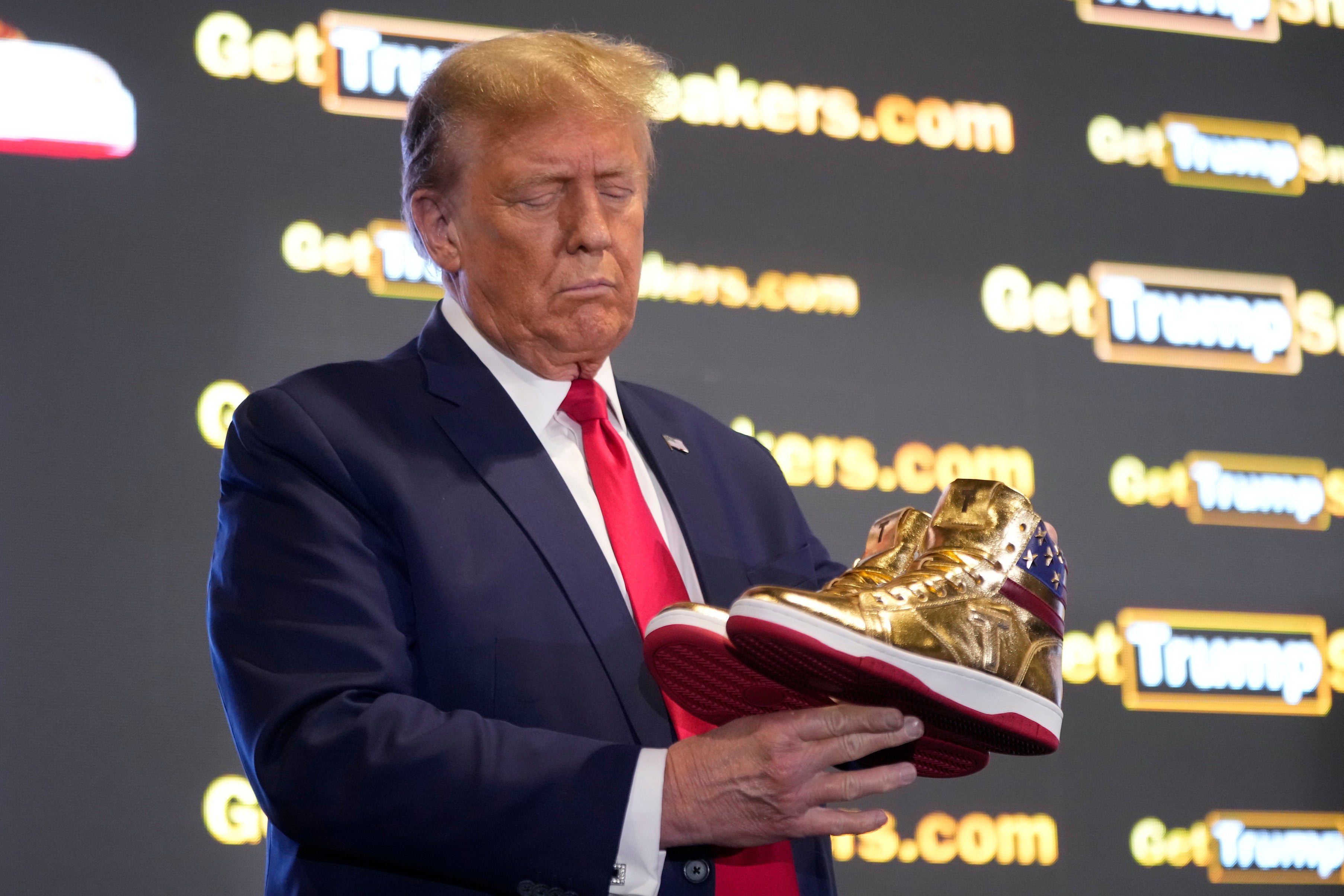 Donald Trump sostiene un par de sus nuevas zapatillas “Never Surrender” en la SneakerCon