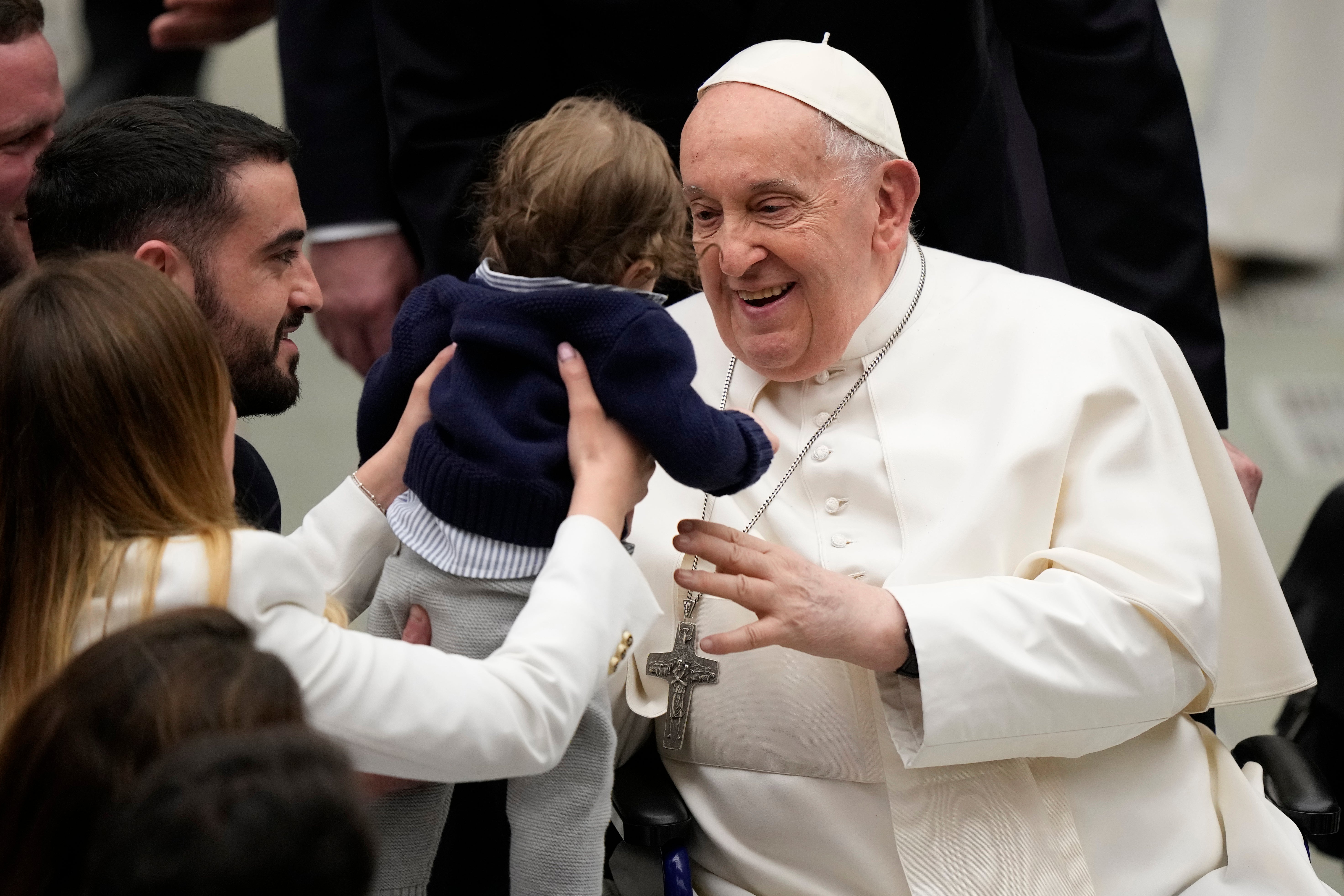 El papa Francisco abraza a un bebé al final de su audiencia general semanal en el Salón Pablo VI, en el Vaticano el miércoles