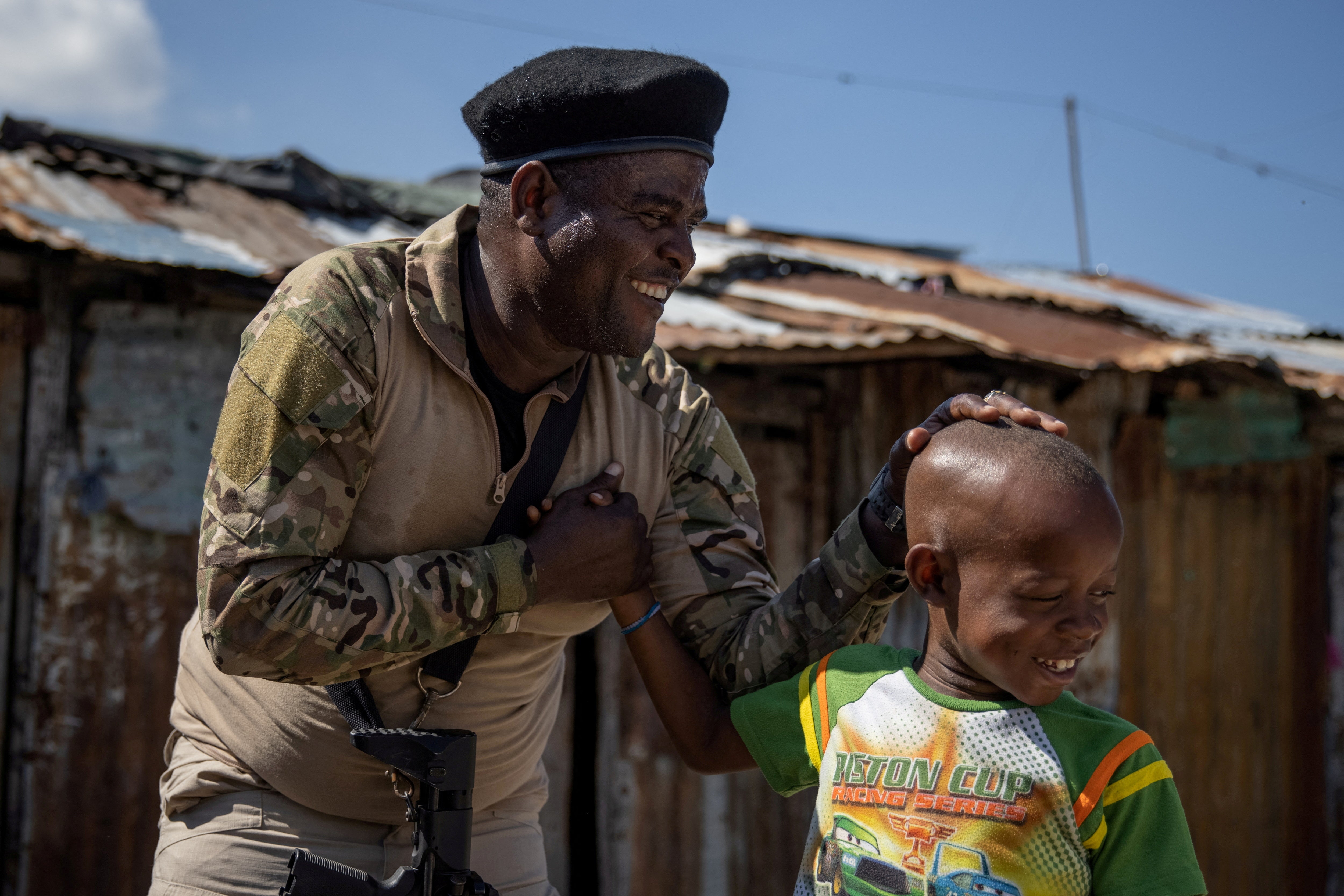 Jimmy “Barbecue” Cherizier, el expolicía y líder de la coalición G9, saluda a un niño durante una visita guiada para la prensa en el barrio marginal de La Saline, en Puerto Príncipe