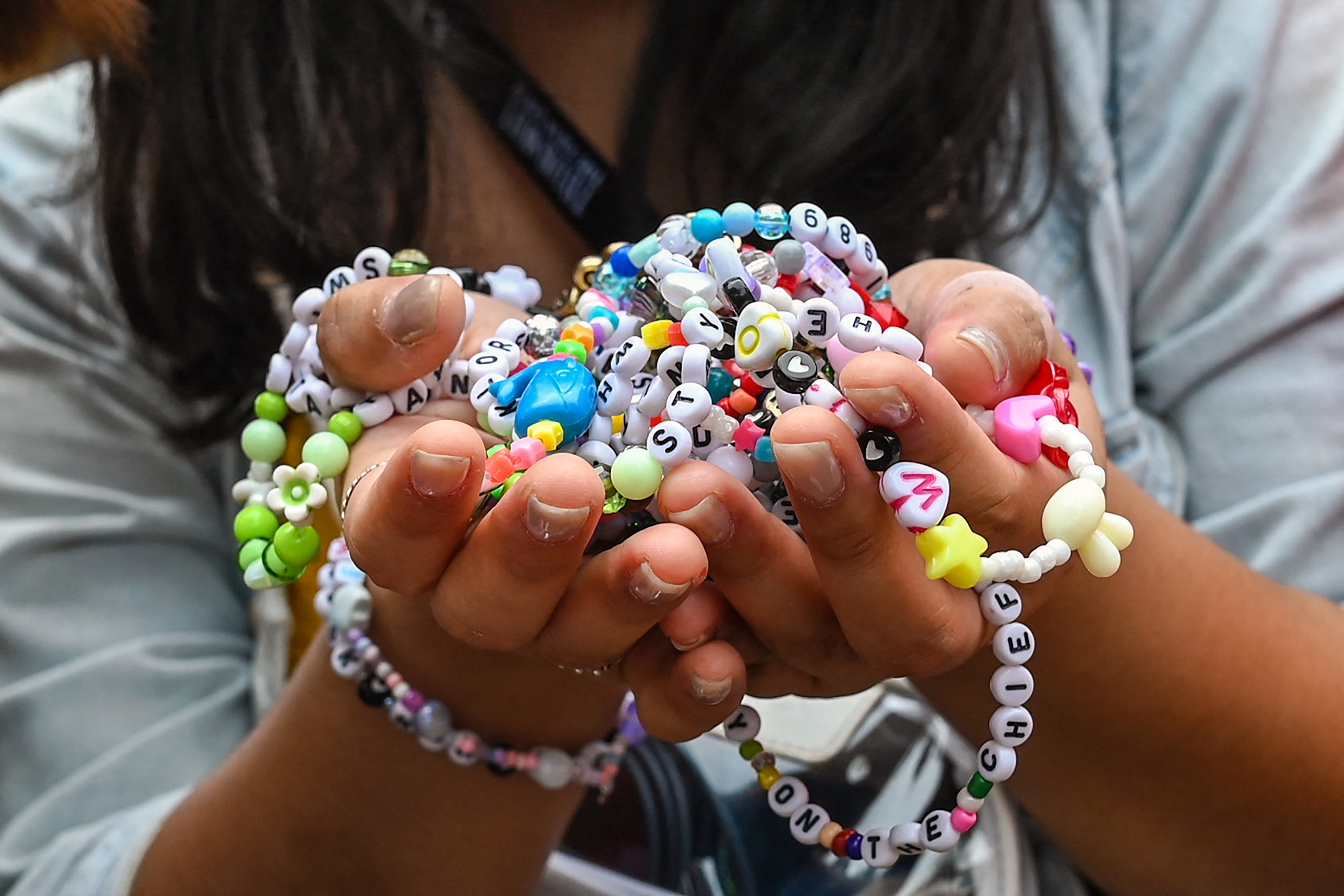 Una Swiftie sostiene pulseras de la amistad a su llegada al Eras Tour