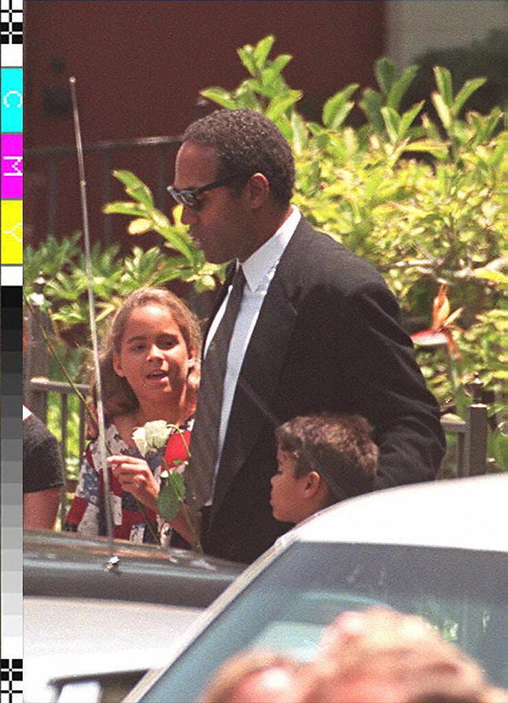 El astro del fútbol americano, O. J. Simpson, acompaña a sus hijos, Sydney, 9 (izq.) y Justin, 6 (der.), a la salida del funeral de su exmujer, Nicole Simpson, 16 de junio de 1994