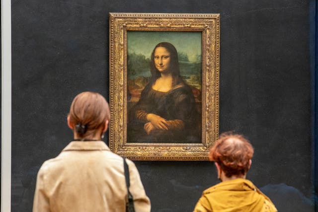 <p> Visitors observe the painting 'La Joconde' The Mona Lisa by Italian artist Leonardo Da Vinci on display in a gallery at Louvre</p>