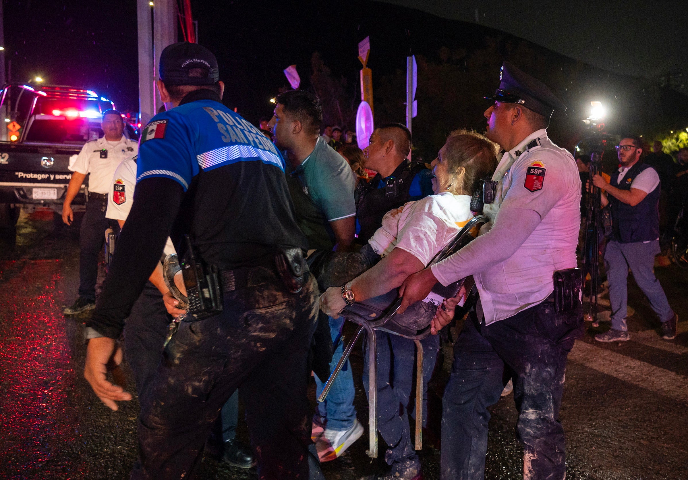 Un grupo de paramédicos evacúa a uno de los heridos tras el derrumbe de un escenario en Nuevo León, México, durante un cierre de campaña