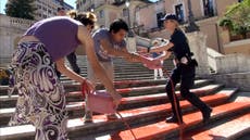 Activistas condenan feminicidios en Italia arrojando pintura en la Plaza Española