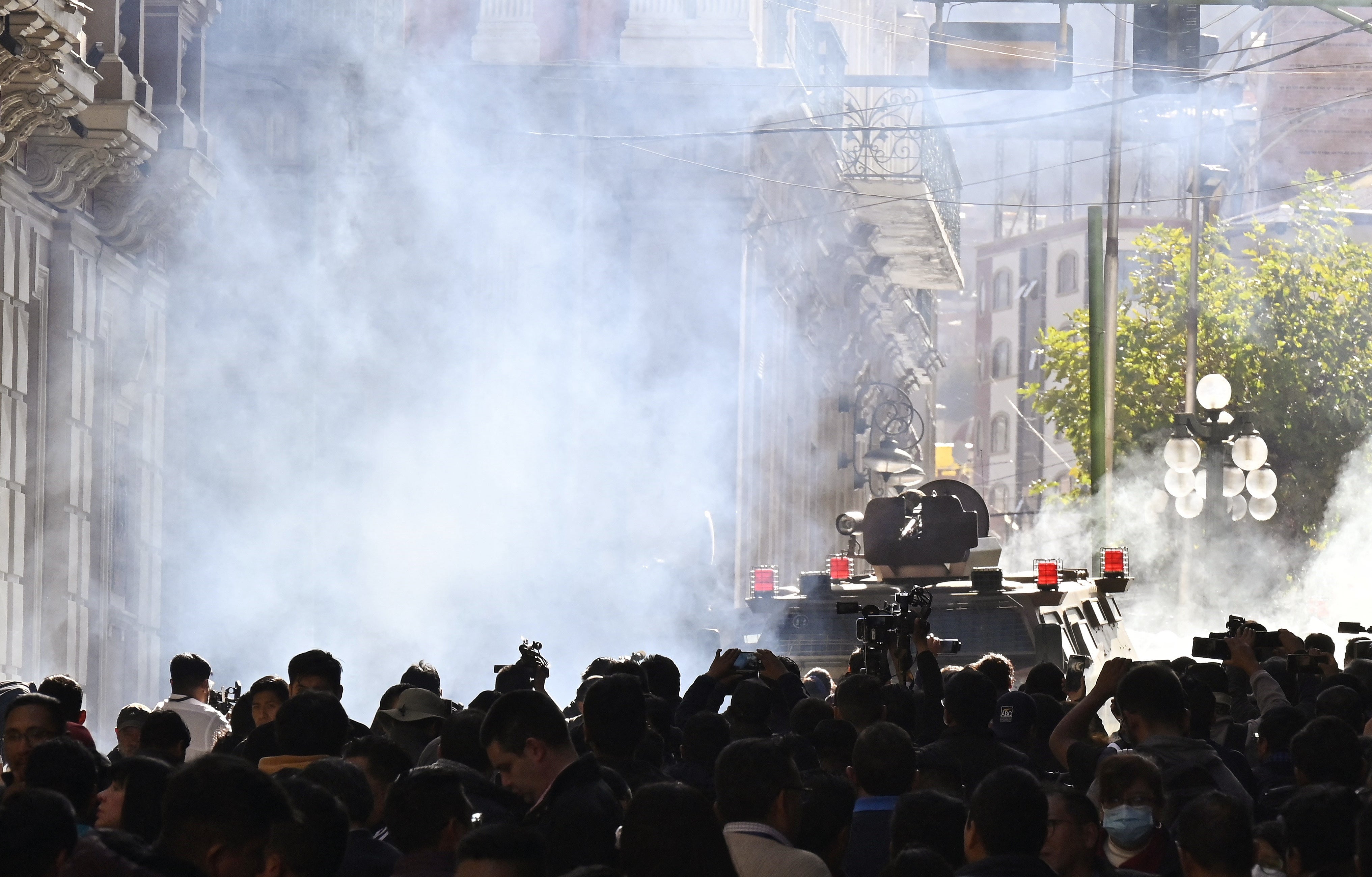 Militares en vehículos blindados disparan gas lacrimógeno a la gente frente al Palacio Quemado en la Plaza Murillo en La Paz