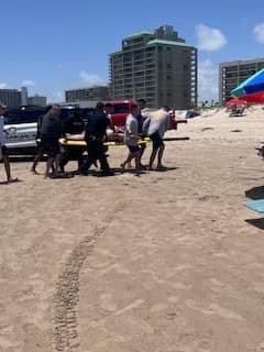 Dos agentes de la Patrulla Fronteriza de la Unidad de Búsqueda, Trauma y Rescate ayudan a una víctima de un ataque de tiburón en la Isla del Padre el 4 de julio