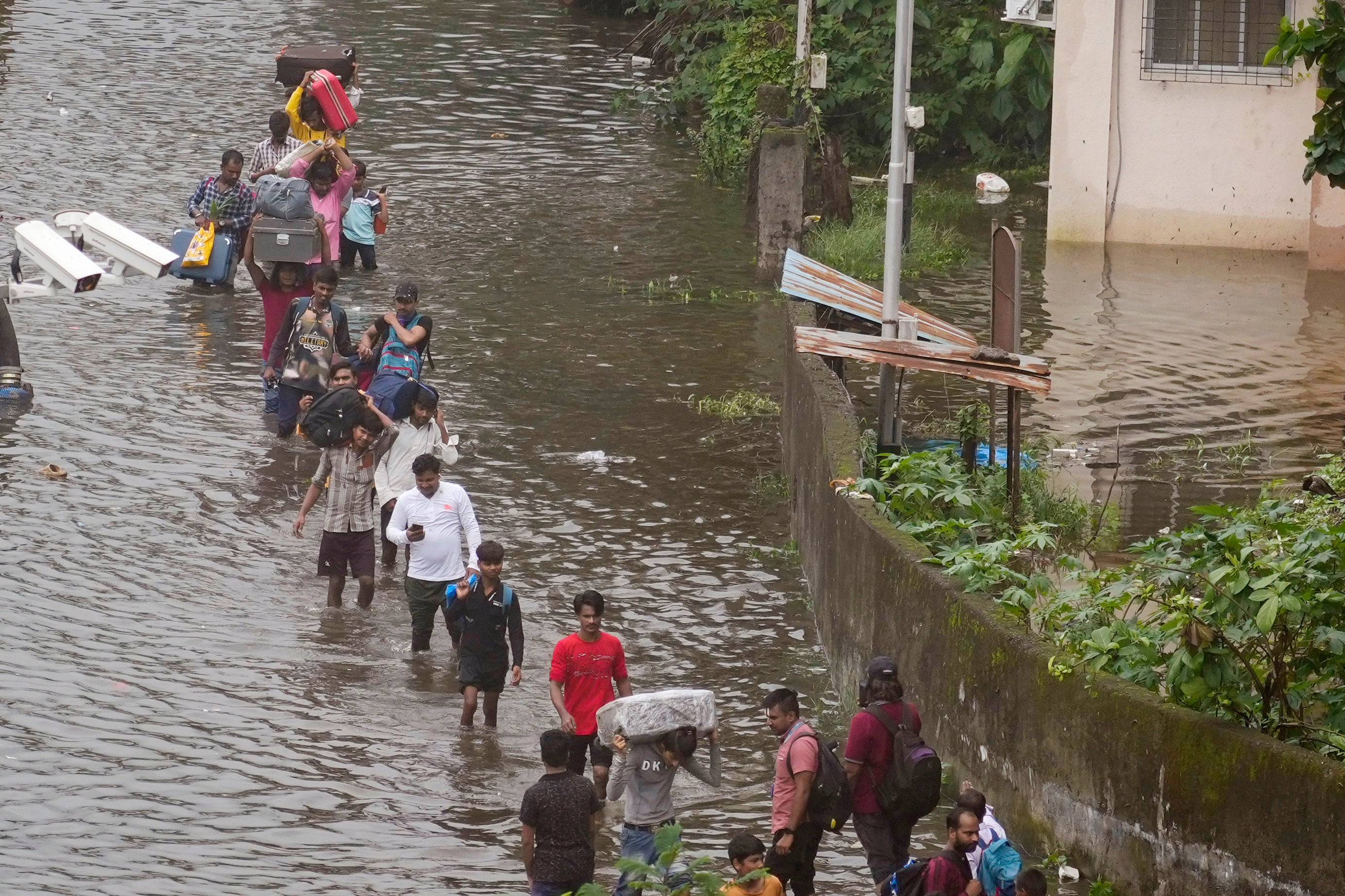 Varios transeúntes circulan por una calle inundada tras las fuertes lluvias en Bombay (India)