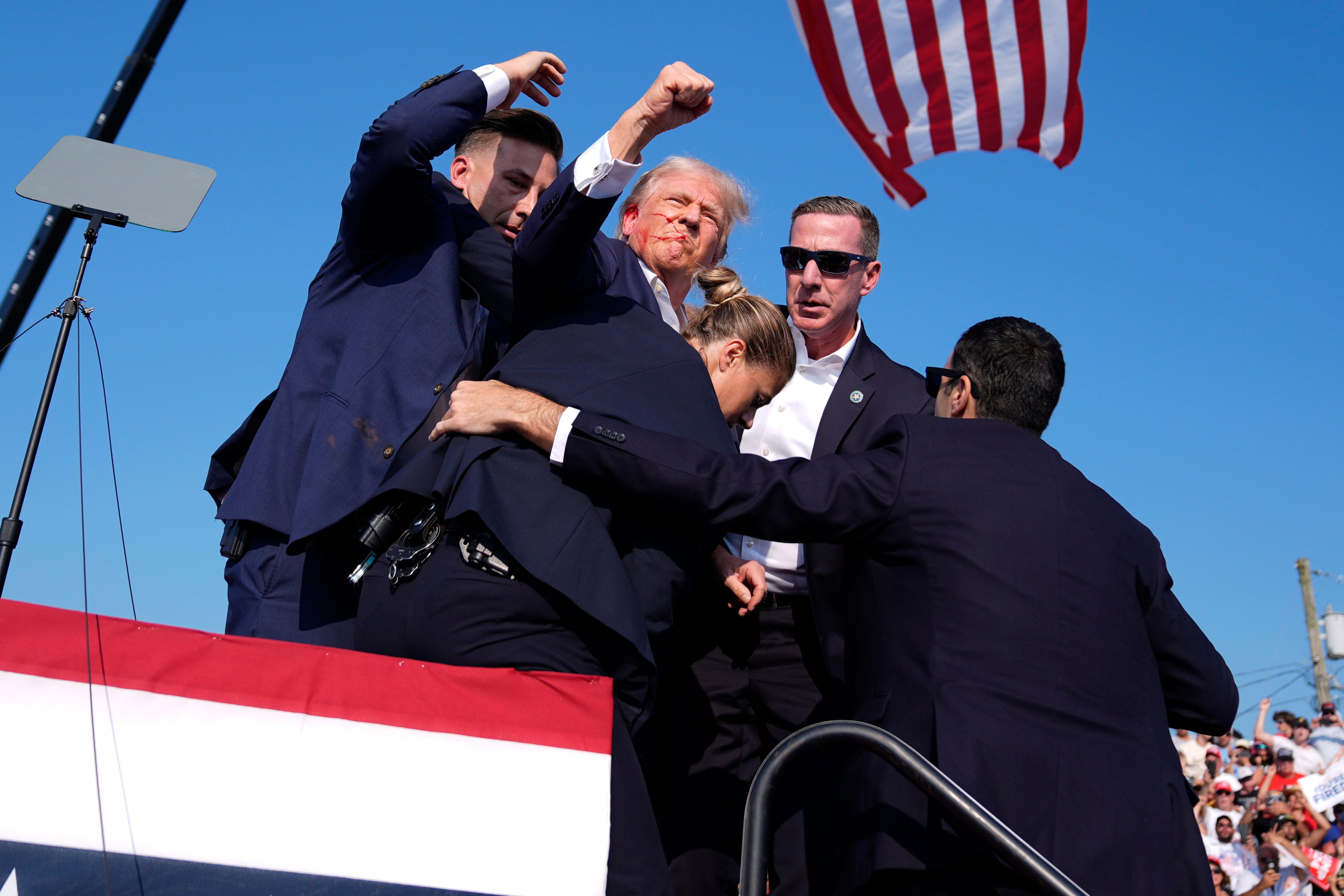 Donald Trump is led from the stage with blood on his face after shots ring out his Pennsylvania rally