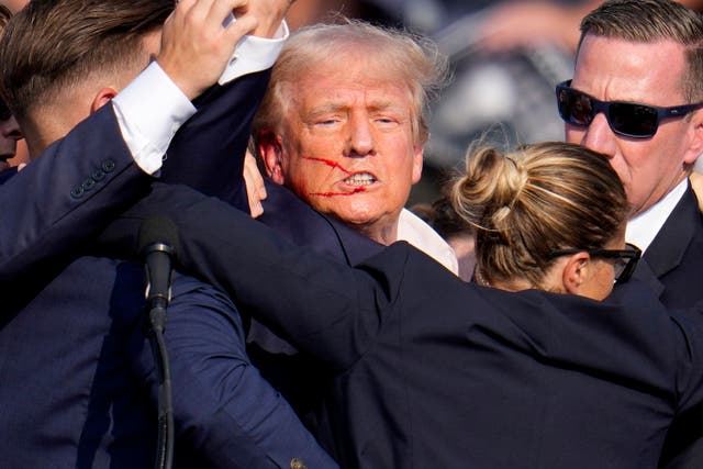 <p>Agentes del Servicio Secreto de Estados Unidos ayudan a bajar del escenario al candidato presidencial republicano, el expresidente Donald Trump, en un acto de campaña en la ciudad de Butler (Pensilvania) </p>