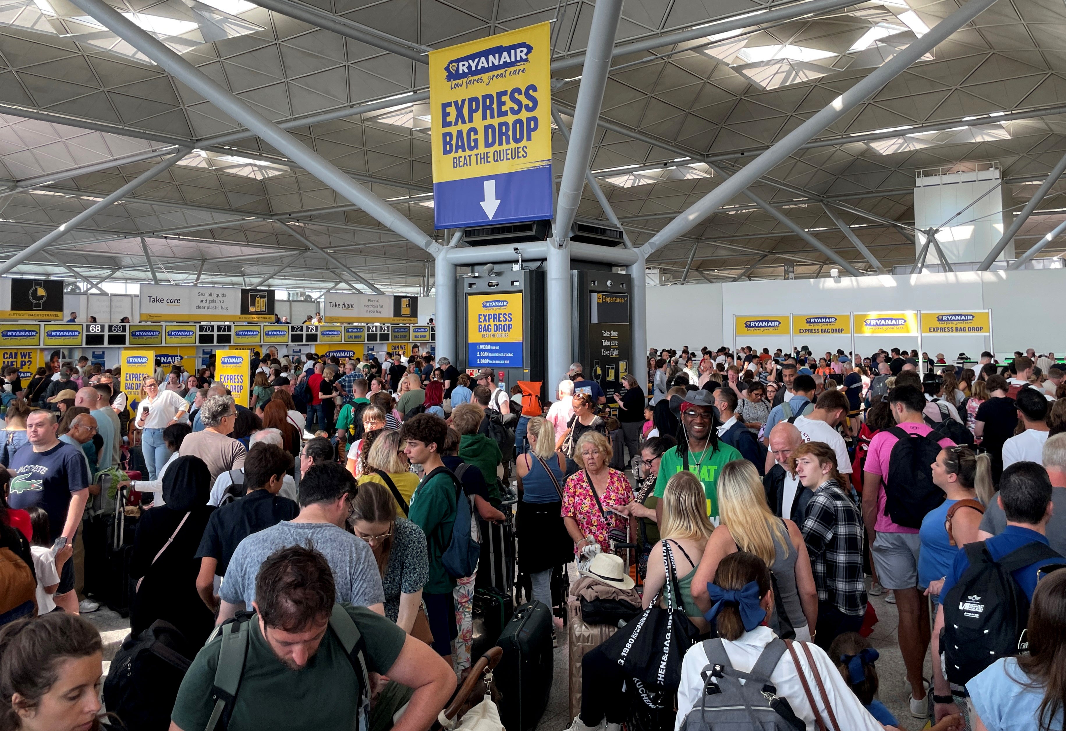 Pasajeros hacen cola junto al mostrador de facturación de Ryanair en el aeropuerto londinense de Stansted