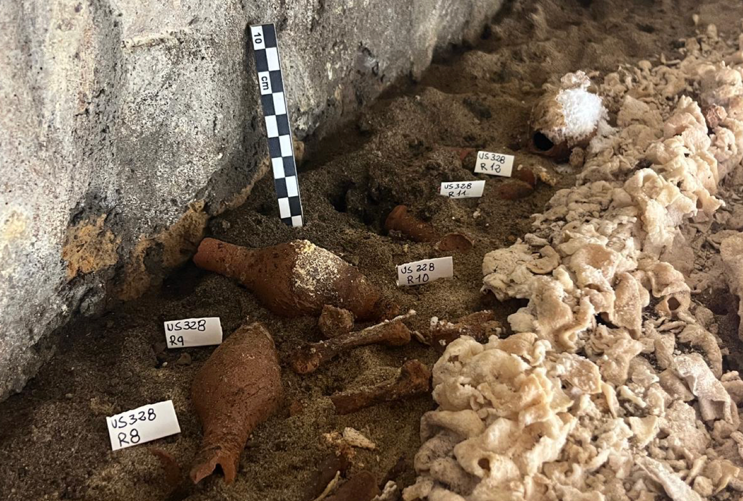 Interior del sarcófago en excavación, con el sudario y algunos elementos de acompañamiento