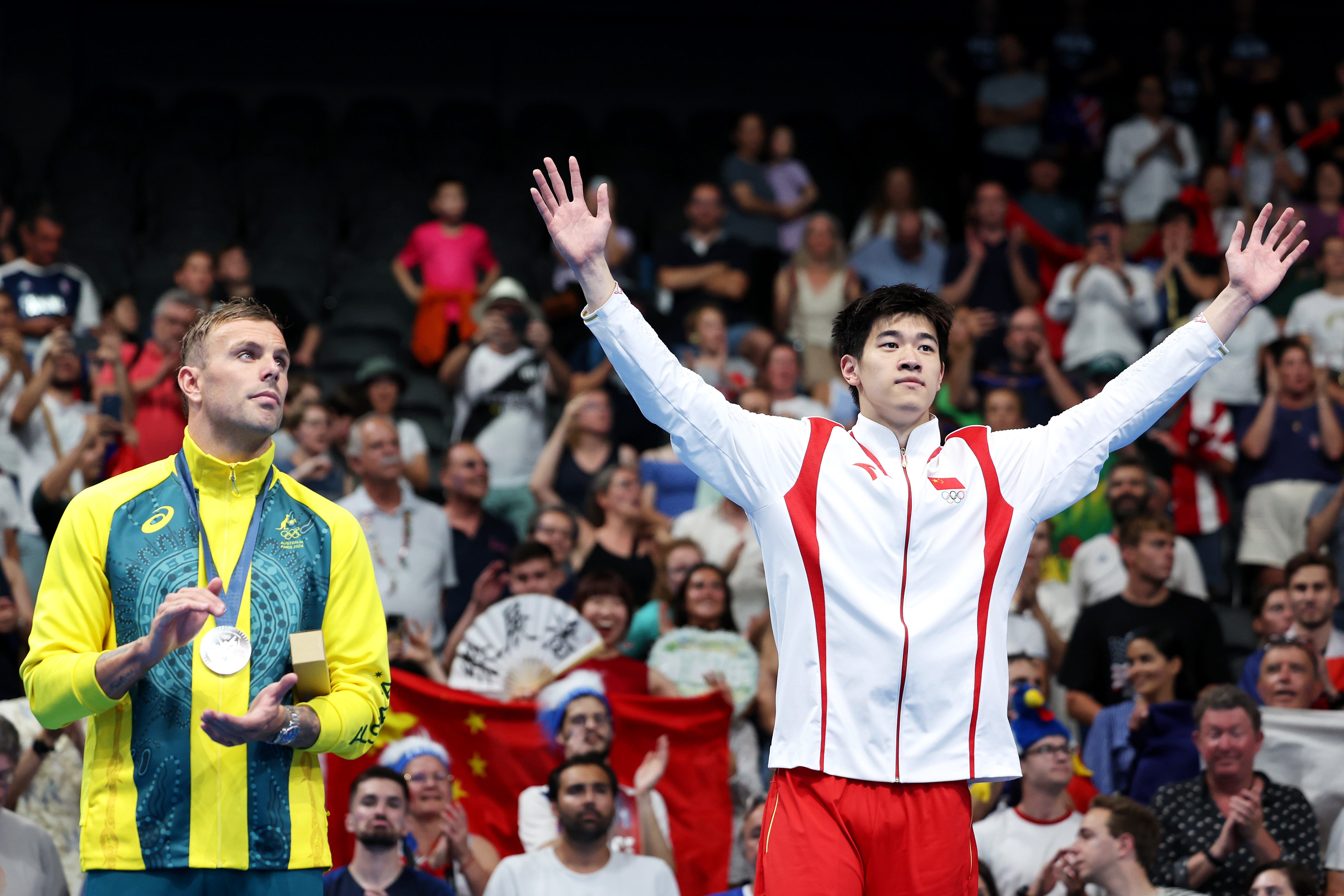 Kyle Chalmers aplaude a Pan Zhanle en el podio olímpico