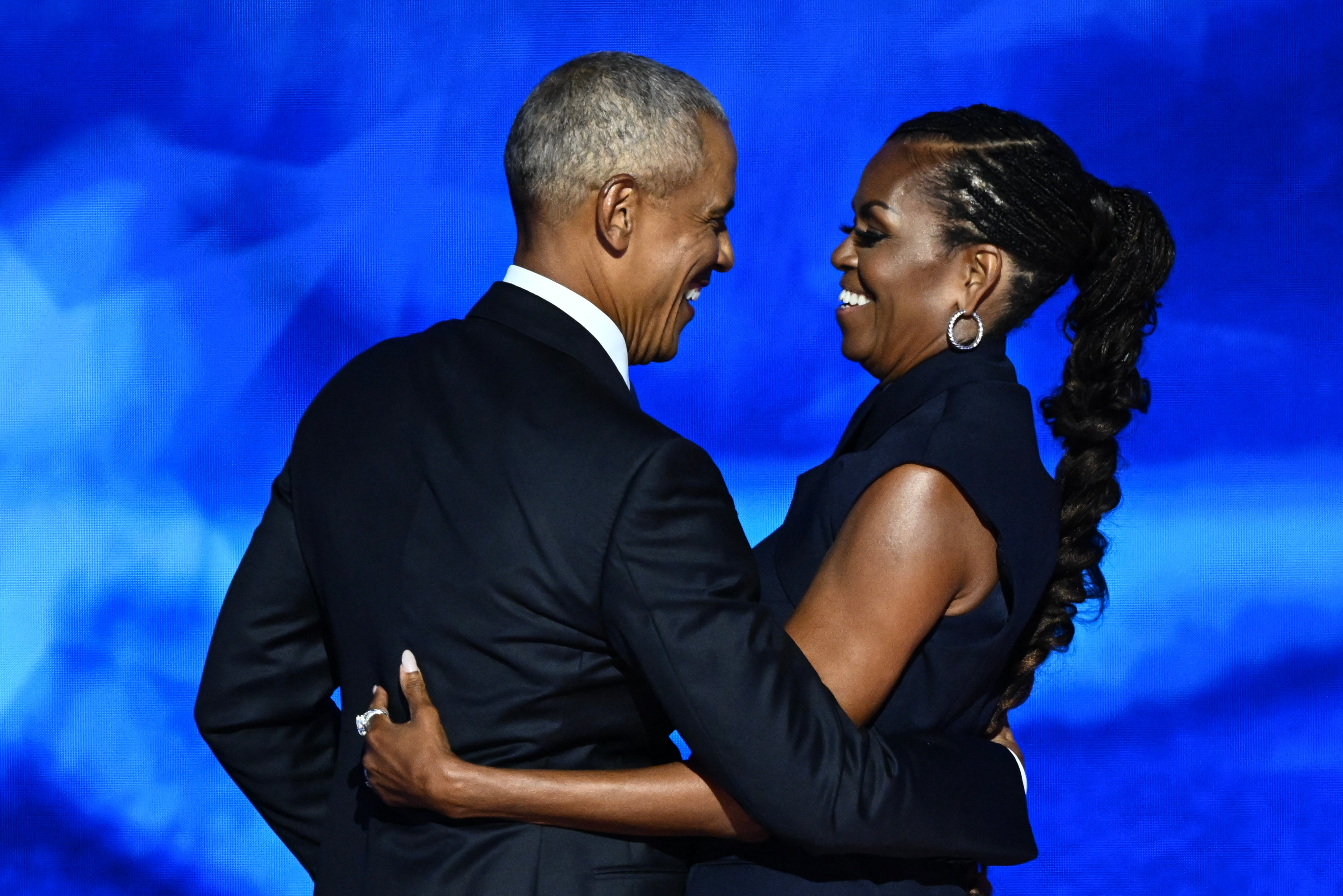 El expresidente estadounidense Barack Obama abraza a su esposa y ex primera dama Michelle Obama después de que ella lo presentara en el segundo día de la Convención Nacional Demócrata (DNC) en el United Center de Chicago, Illinois, el 20 de agosto de 2024. (Foto de MANDEL NGAN/AFP mediante Getty Images)