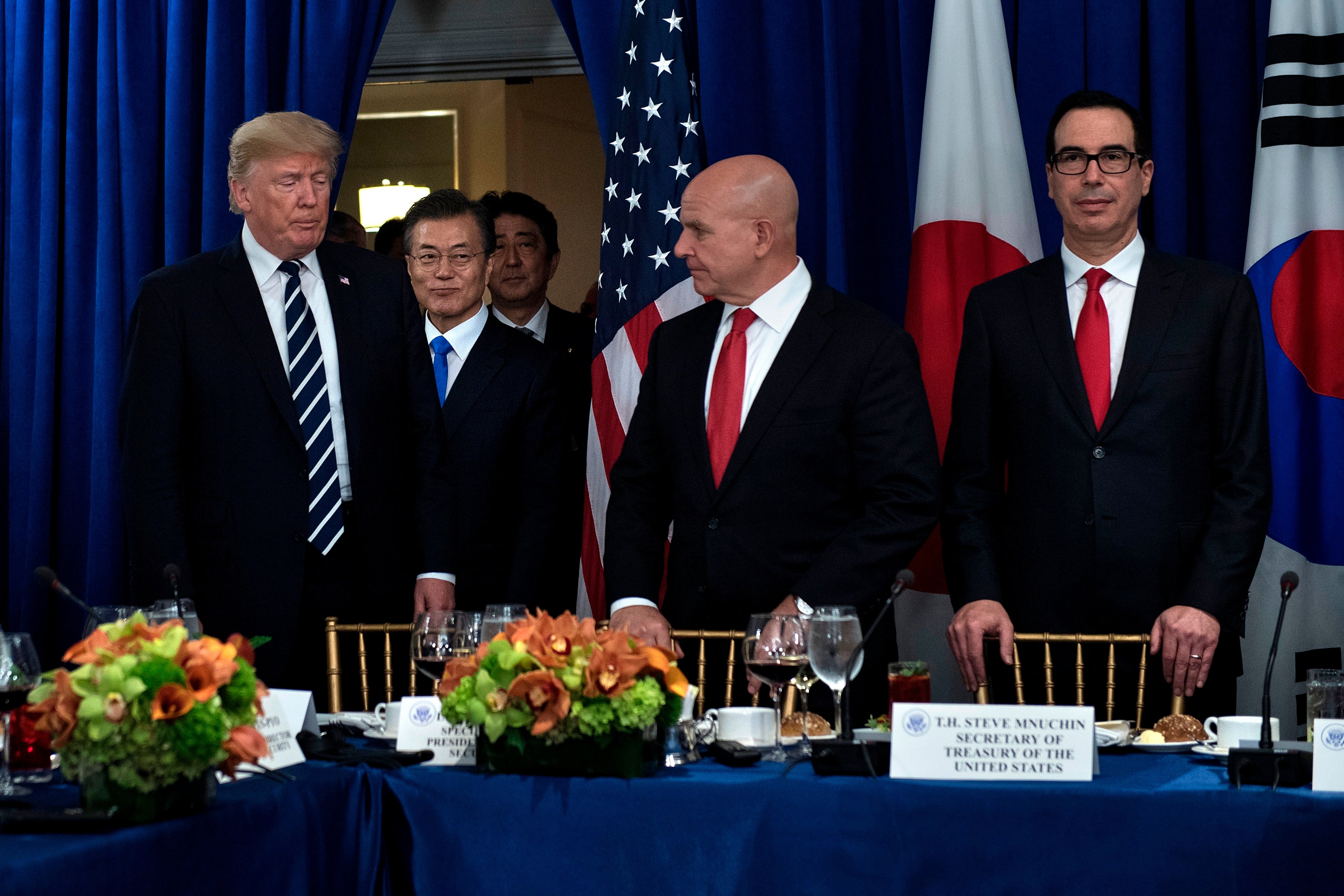 El consejero de seguridad nacional H. R. McMaster y el secretario del tesoro Steven Mnuchin esperan mientras el entonces presidente de EE. UU., Donald Trump, el presidente de Corea del Sur Moon Jae-in, y el primer ministro de Japón Shinzo Abe llegan a un almuerzo en el Hotel Palace, Nueva York, durante la 72ᵃ Asamblea de las Naciones Unidas, el 21 de septiembre de 2017. McMaster escribió un mordaz retrato de Trump en su autobiografía, recientemente publicada