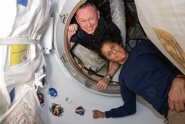 <p>Los astronautas de la NASA Butch Wilmore y Suni Williams posan el 13 de junio de 2024 en el vestíbulo entre las naves espaciales Starliner de Boeing</p>