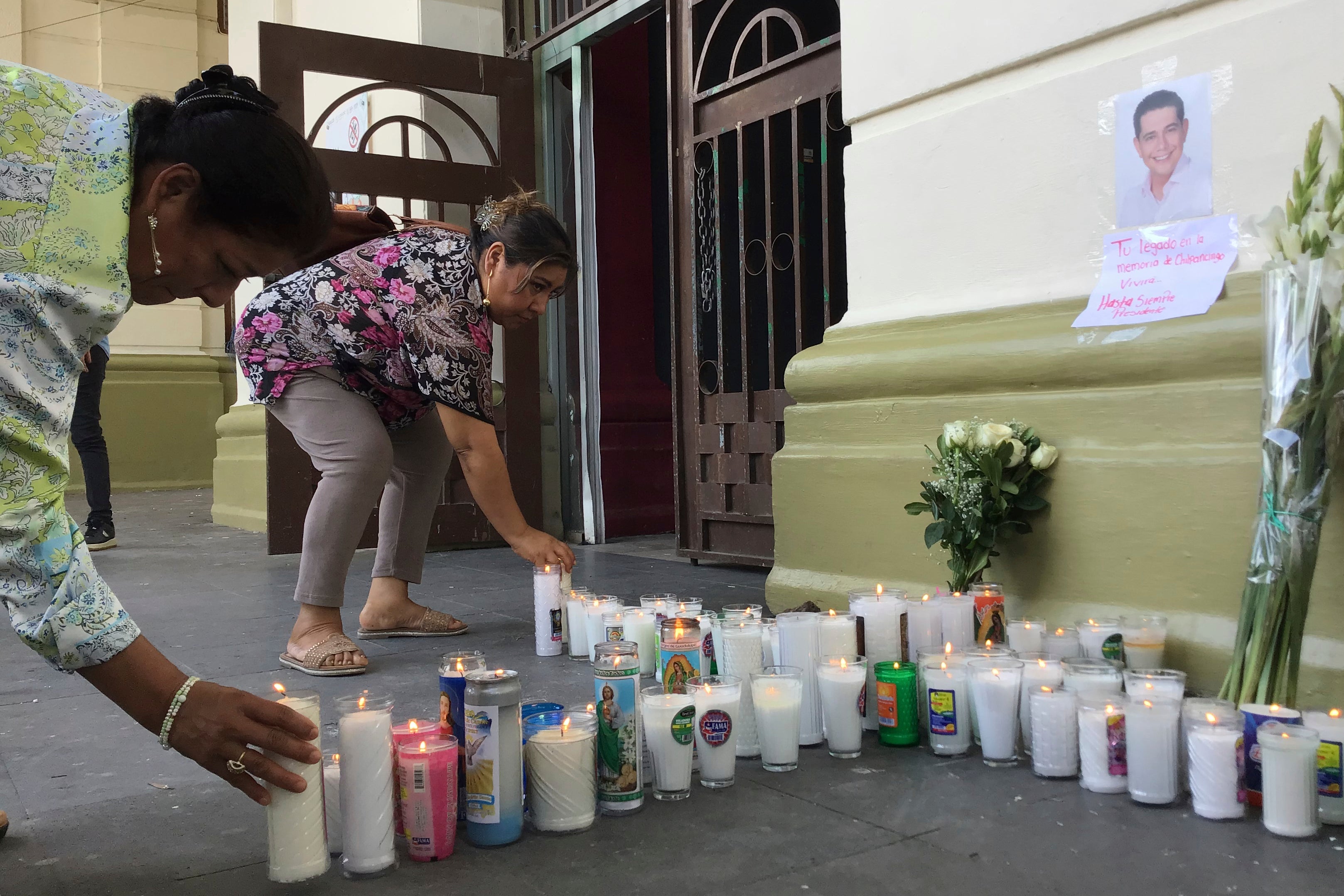 Simpatizantes del alcalde asesinado Alejandro Arcos colocan velas y flores a la entrada del edificio municipal una semana después de su toma de posesión en Chilpancingo, México