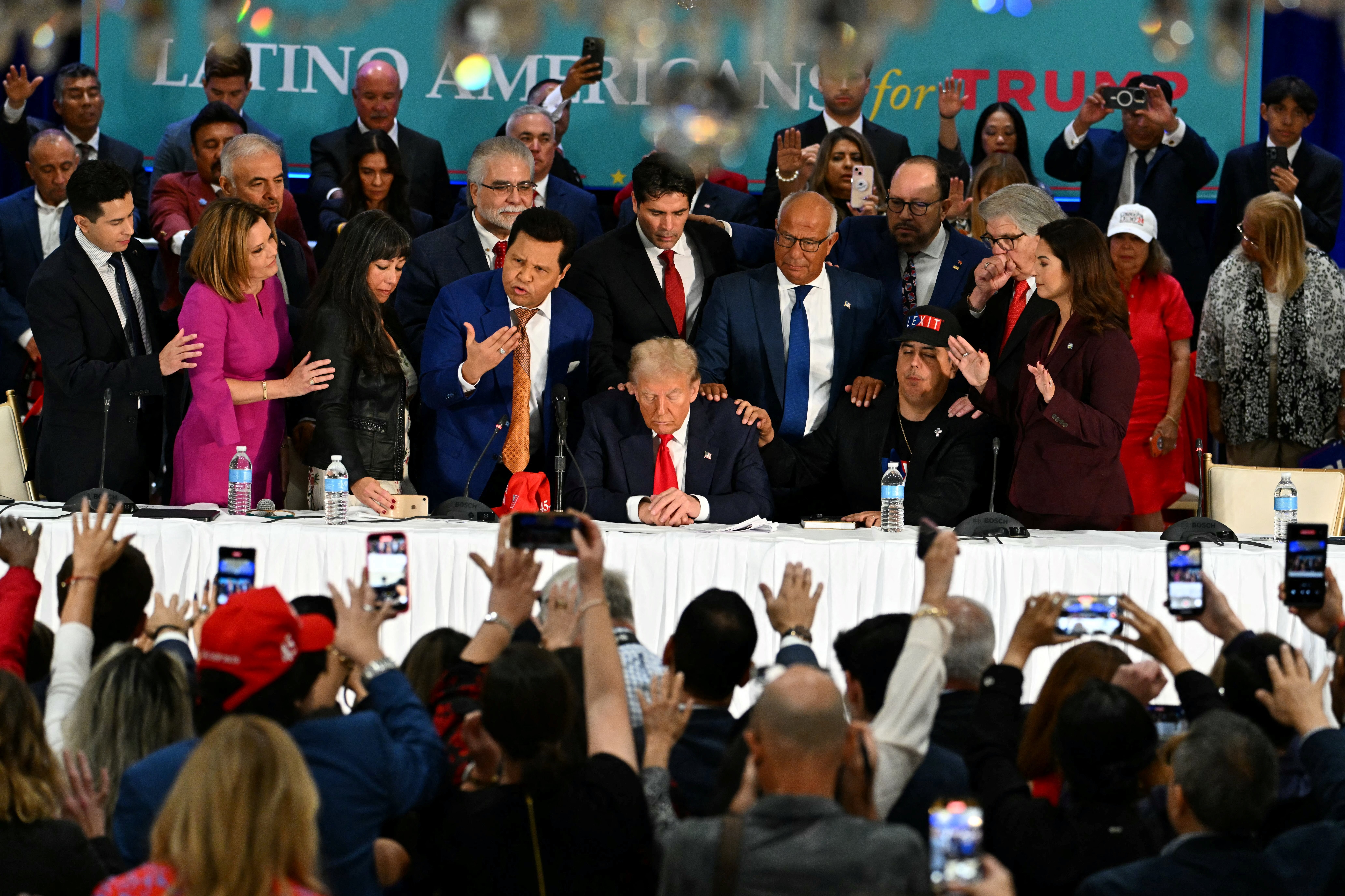 El expresidente Donald Trump participa en una oración durante una mesa redonda con líderes de la comunidad latina, realizada en el resort Trump National Doral en Miami. Durante el evento, también fue agasajado con una variedad de obsequios