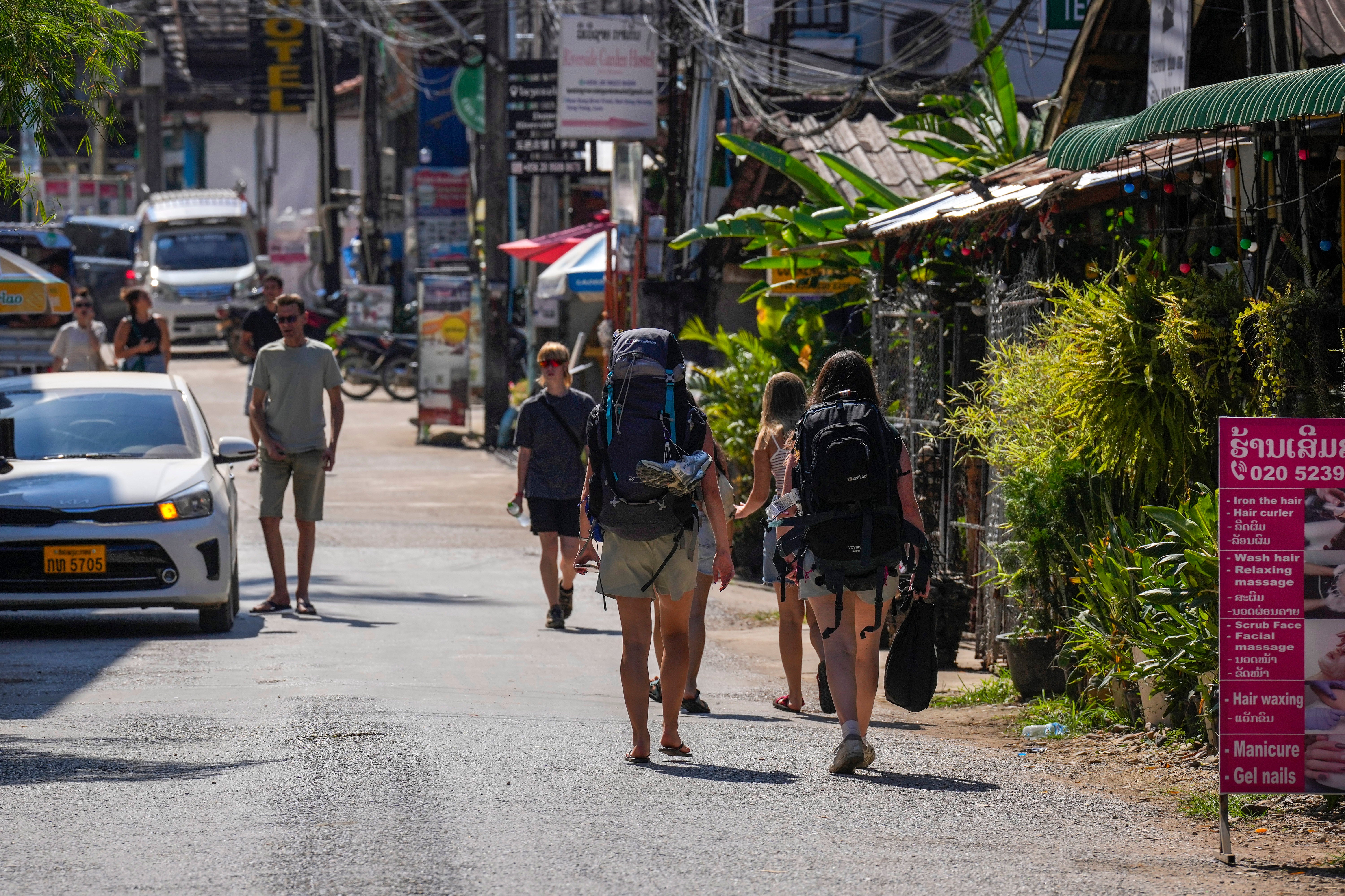 Los mochileros recorren las calles de Vang Vieng este viernes. Algunos declaran a la prensa que, ante las sospechas de envenenamiento, optan por beber solo de botellas selladas