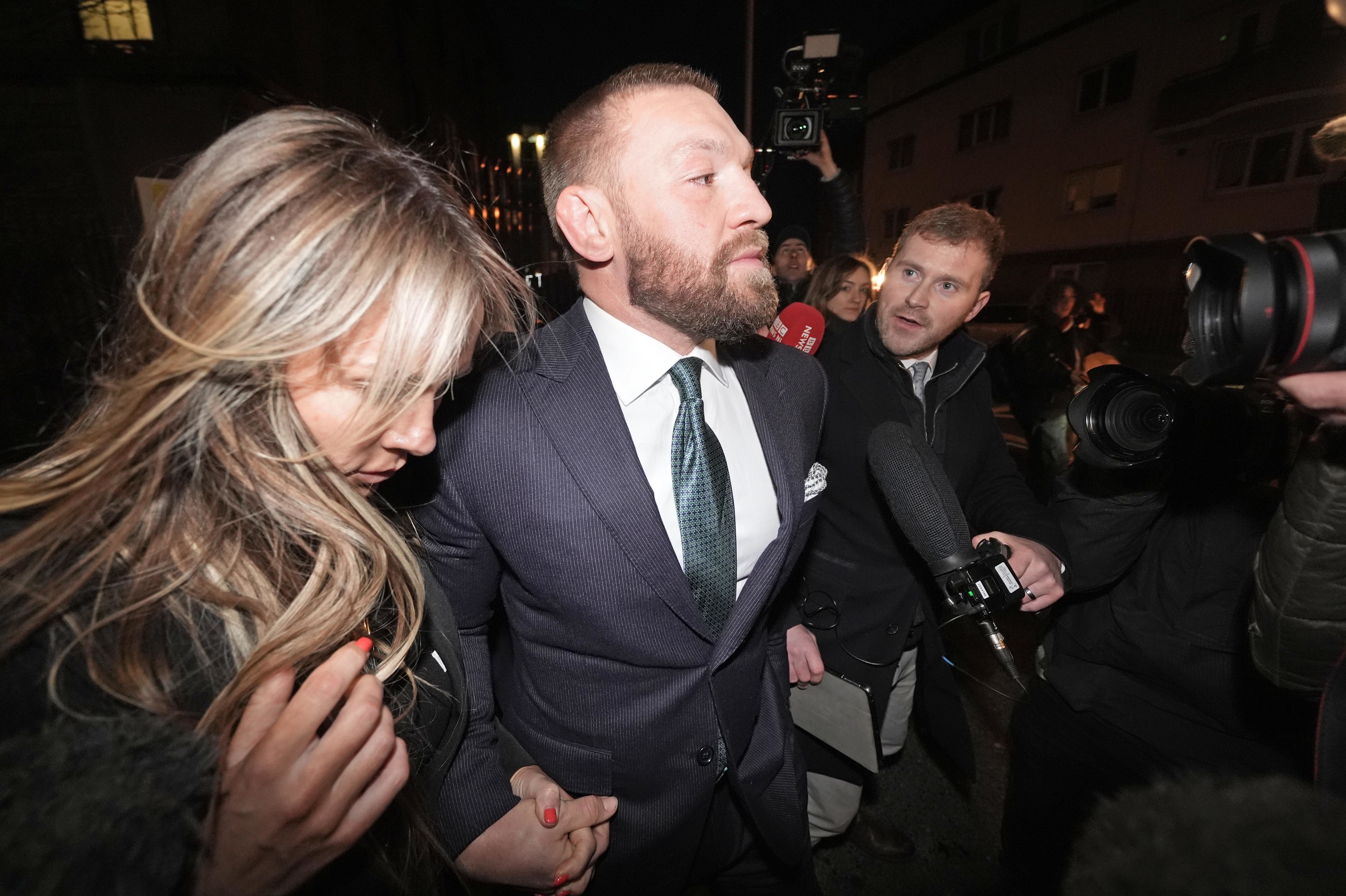 El luchador de artes marciales mixtas Conor McGregor y su pareja, Dee Devlin, salen del Tribunal Superior en Dublín